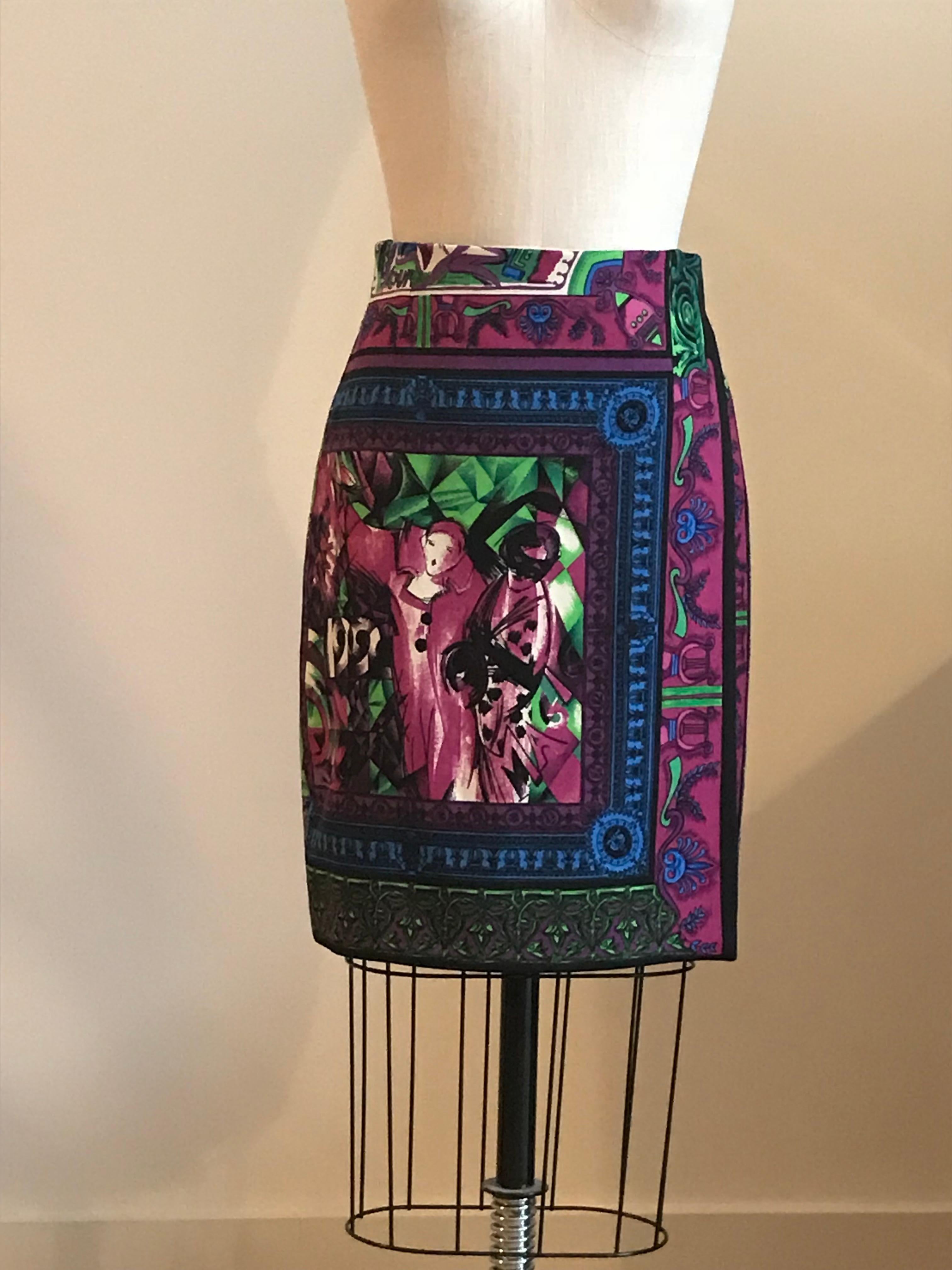 Gianni Versace 1990s skirt in a faux wrap style features wild signature print in purple, fuchsia, blue, and green. Front features two ladies who appear to be going to a masquerade ball with abstract print reading '1990' and back features intricate