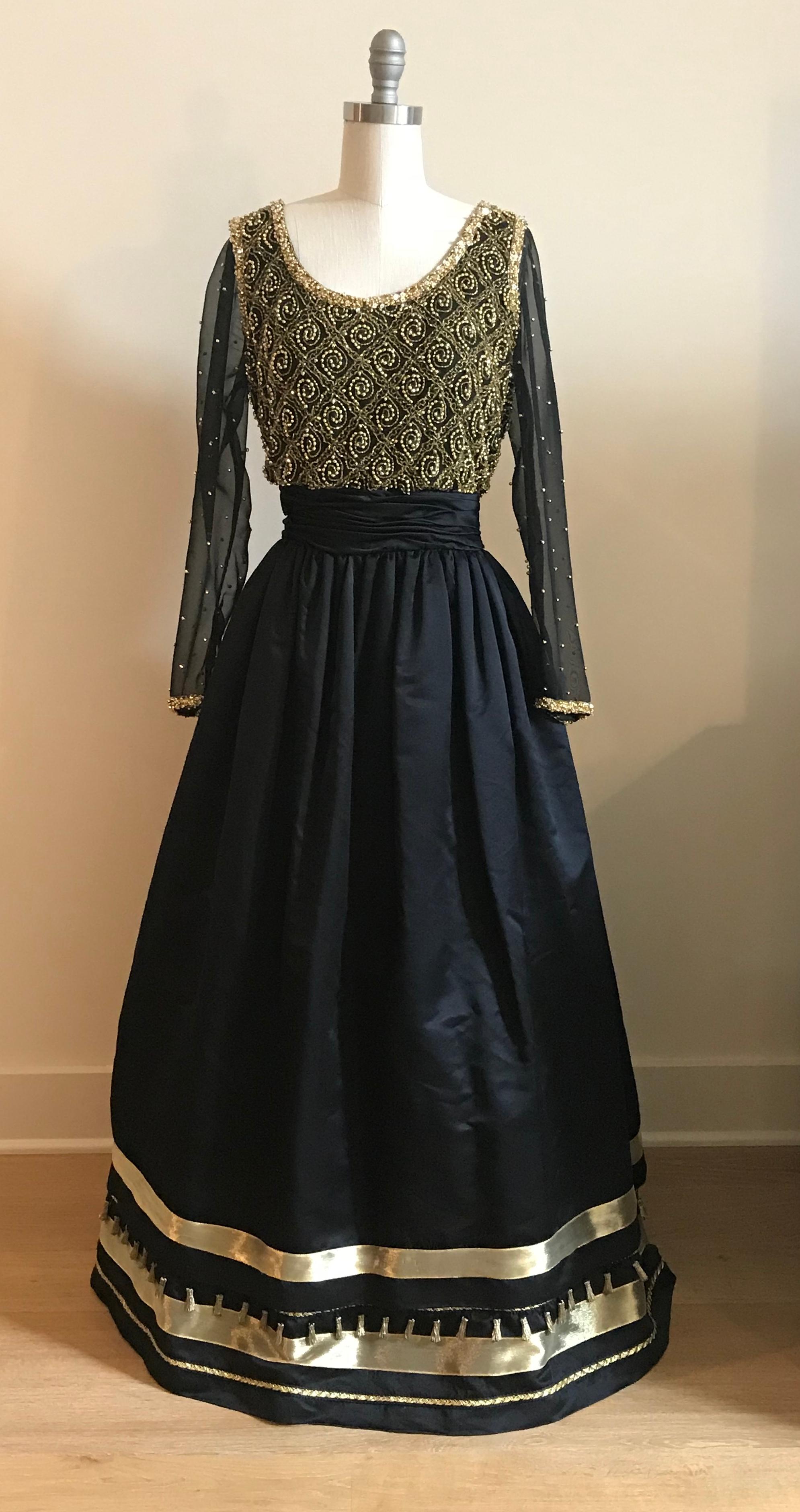 Amazing long sleeve black Victoria Royal Ltd. full length gown with gold bead embellishment at bodice and sleeves. Gold ribbon trim at hem and tiny gold tassels adorn the bottom. Back zip with concealed snaps that fasten over zipper at upper back