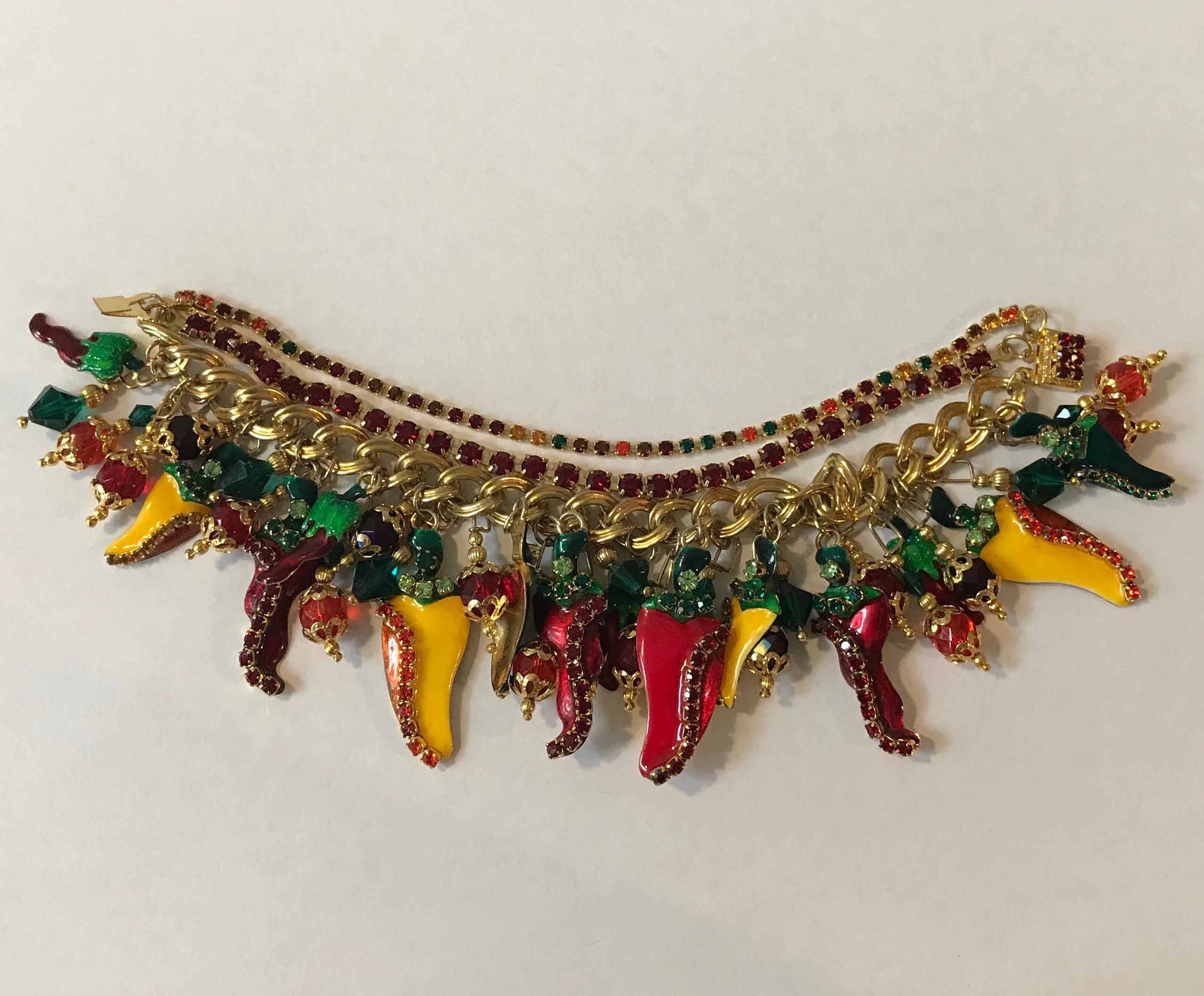 Lunch at the Ritz vintage 1990s gold tone chili pepper theme bracelet featuring enamel and rhinestone details. This over the top pepper themed costume jewelry bracelet features yellow, red, and green enamel pepper charms accented with rhinestones on