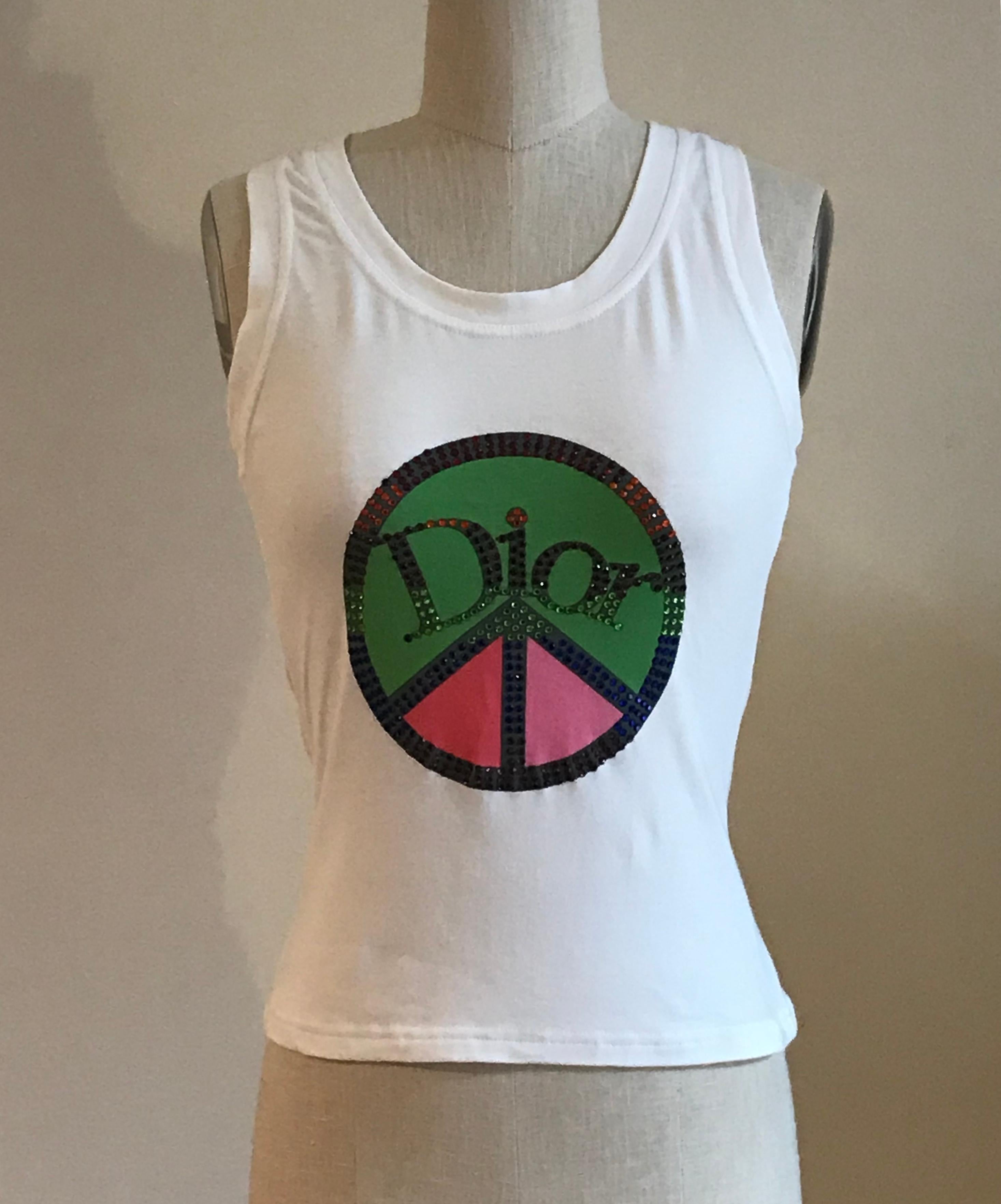 Christian Dior white sleeveless t-shirt style tank top featuring a multicolored crystal embellished peace sign and Dior logo at front and 1947 in crystals at back. 

95% cotton, 5% lycra.

Made in Italy.

Labelled French 40, US 8 but seems to better