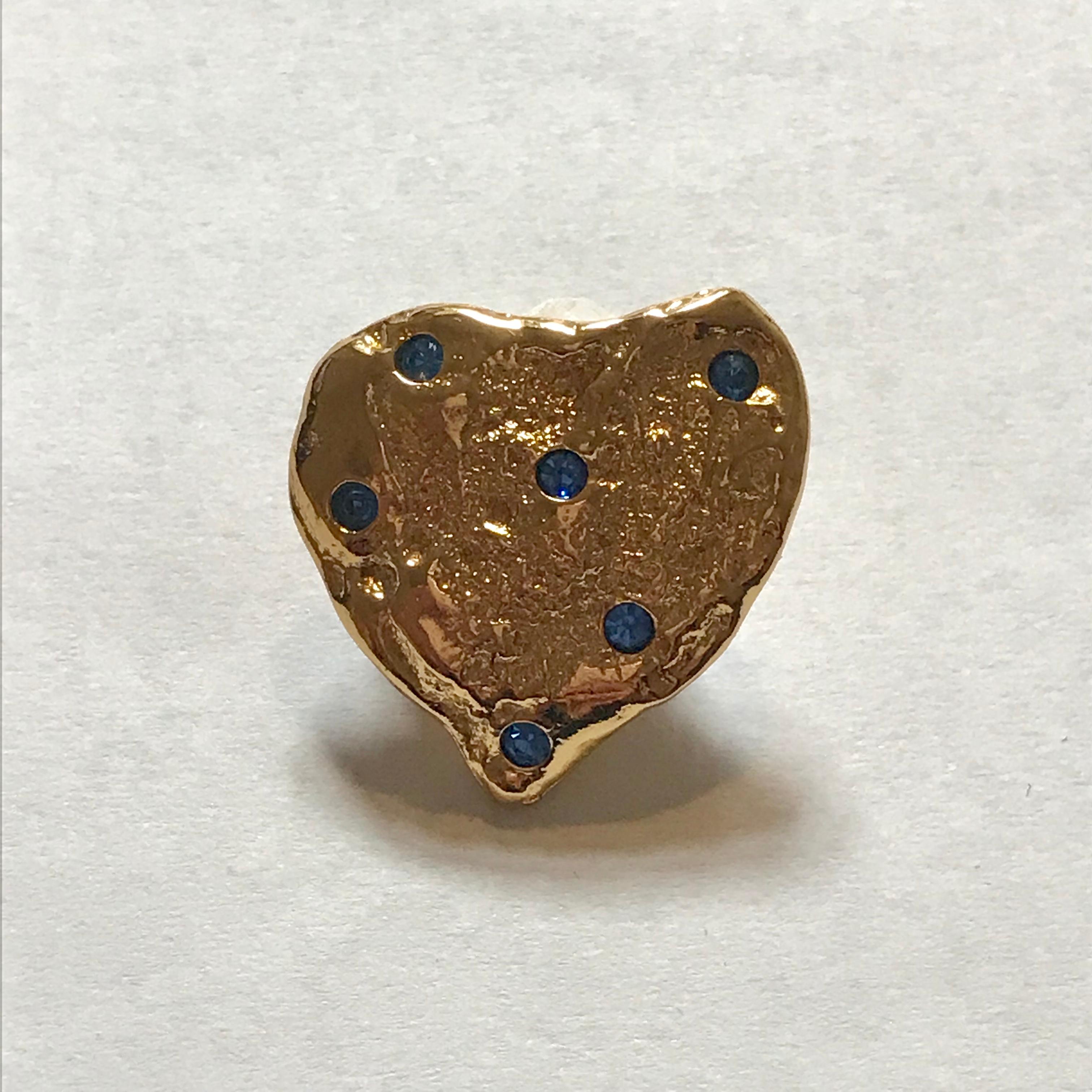 Yves Saint Laurent small textured gold tone brooch in an abstract heart shape, accented with small blue crystals throughout. A truly iconic piece, as the heart motif  was a recurring symbol throughout the designs of Saint Laurent for his whole