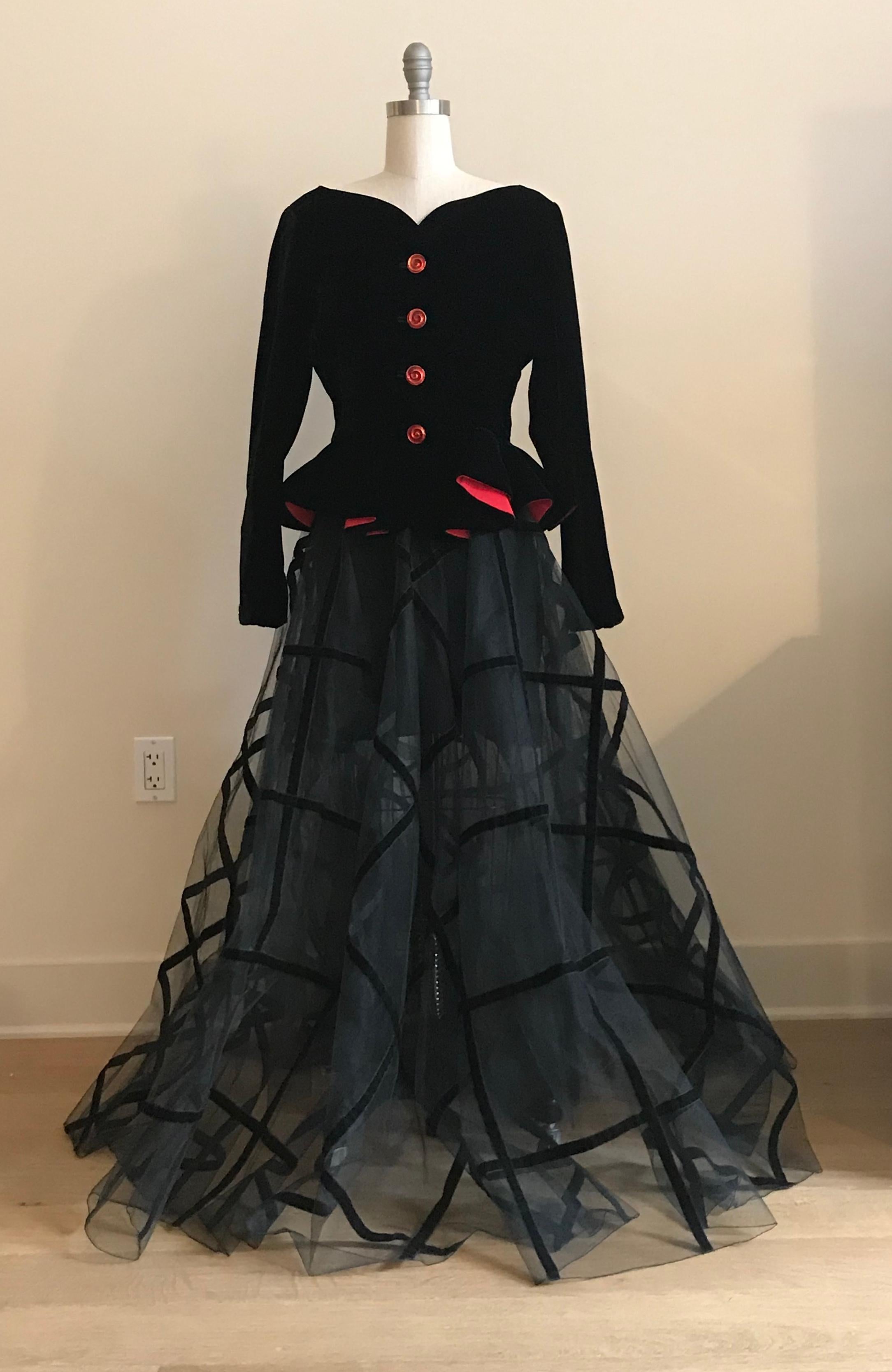 Yves Saint Laurent Rive Gauche 1990s skirt suit featuring a black double layered tulle ball gown style skirt with black velvet trim and a black velvet jacket with red lining and gold and red novelty buttons. Skirt is semi sheer with an attached
