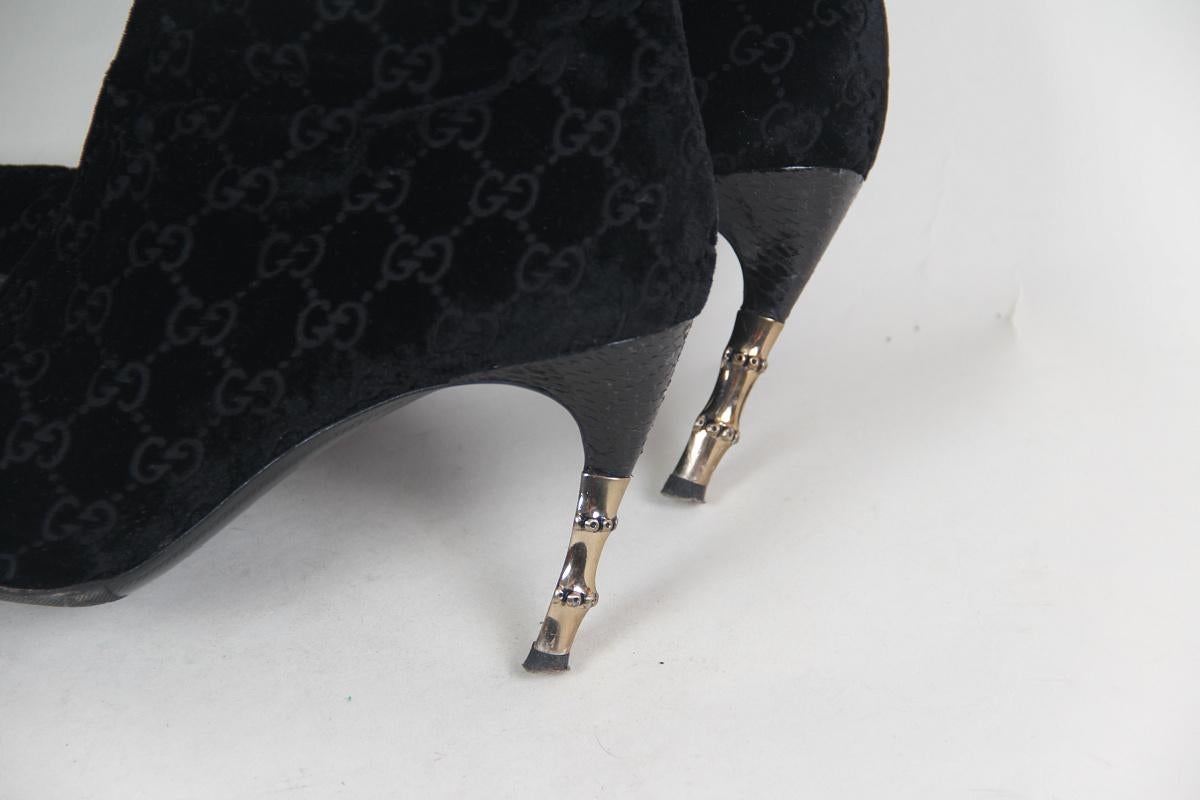 Guccı by Tom Ford FW 2004 monogram boots
Black velvet boots with embossed logos, a reptilian leather insert on the heel and a golden metal insert. Traces of socks


