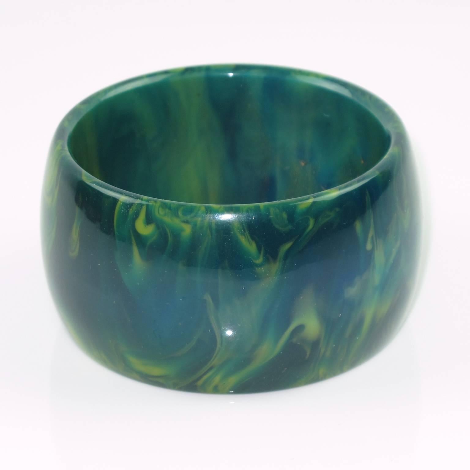 Vintage blue-moon marble Bakelite bracelet bangle. Oversized wide domed shape. Intense blue marble tone with green cloudy swirling. Excellent vintage condition.

Measurements: Inside across = 2.5 in. (6.4 cm) - outside across = 3.07 in. (7.8 cm) -