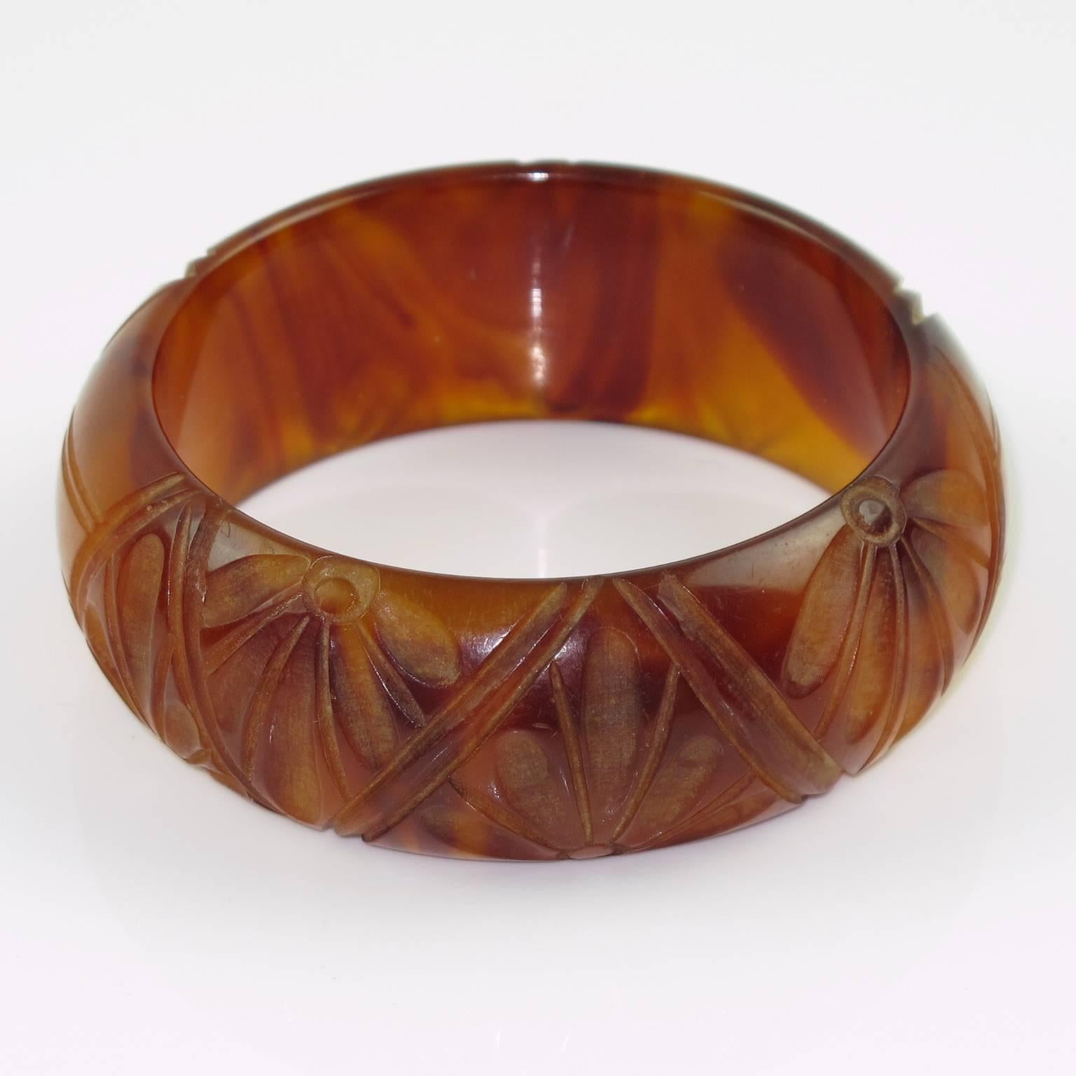 Vintage rootbeer and amber marble marble Bakelite carved bracelet bangle. Domed shape with deep geometric and floral carving all around. Intense amber marble tone with rootbeer cloudy swirling, lots of translucency. Excellent vintage condition.