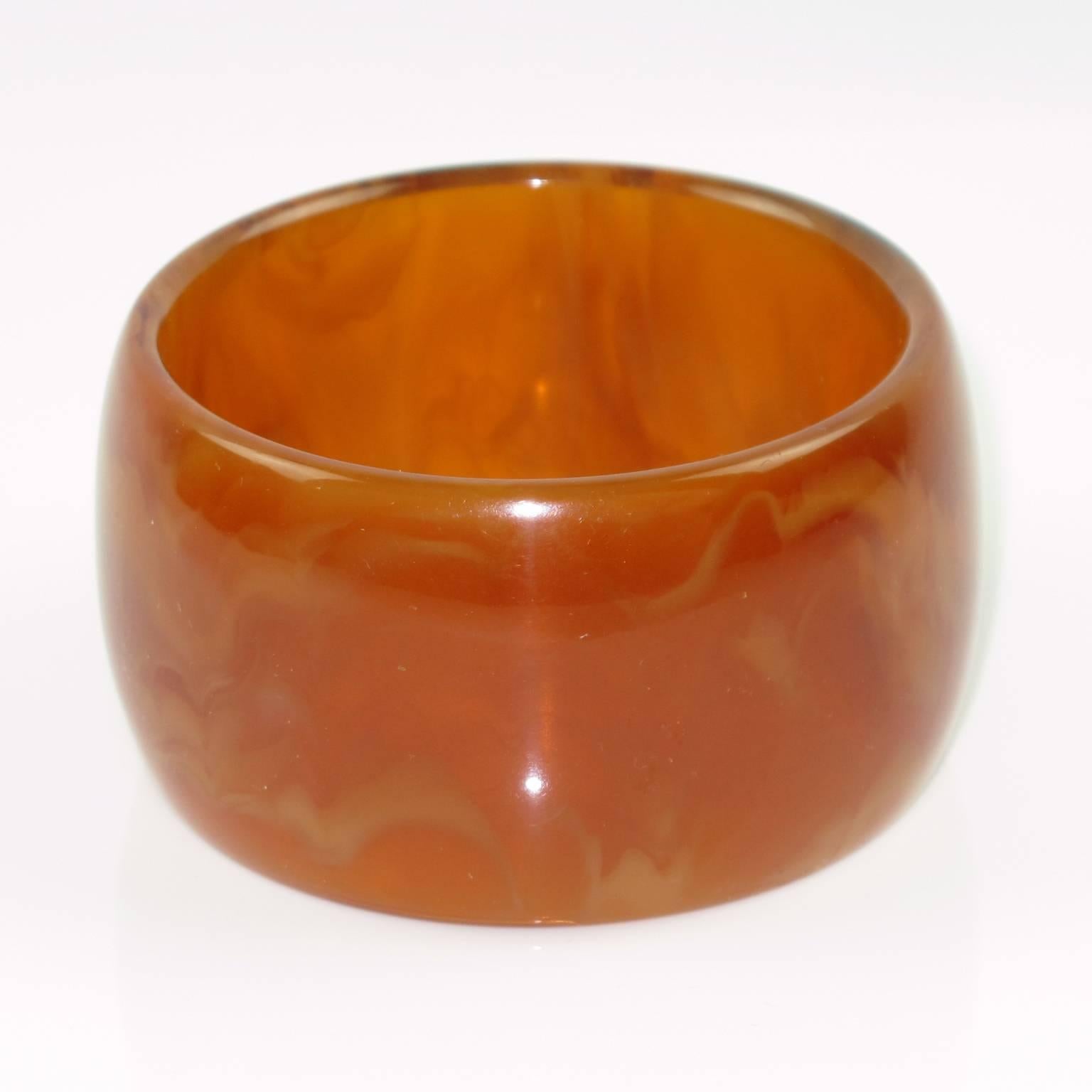 Vintage honey amber marble Bakelite bracelet bangle. Extra wide domed shape. Intense amber marble tone with honey cloudy swirling and lots of translucency. Excellent vintage condition. France, circa 1950s.

Measurements: Inside across = 2.63 in.