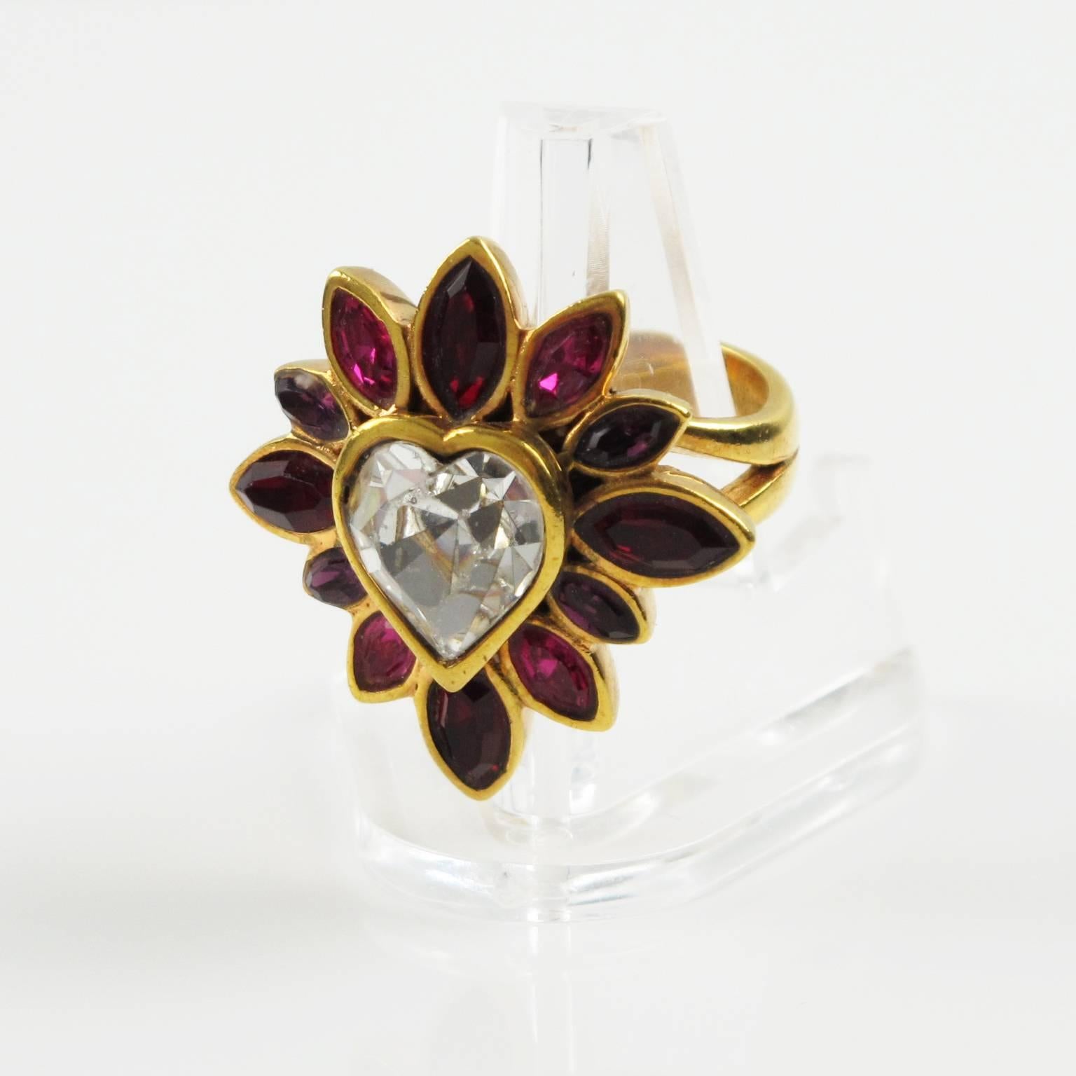Vintage 1980s gorgeous jeweled cocktail ring by YVES SAINT LAURENT, YSL Paris. Floral shape with large band in gold plated metal ornate with rhinestone in pear shape. Assorted color of hot pink, ruby red and purple. Center of ring is a huge clear