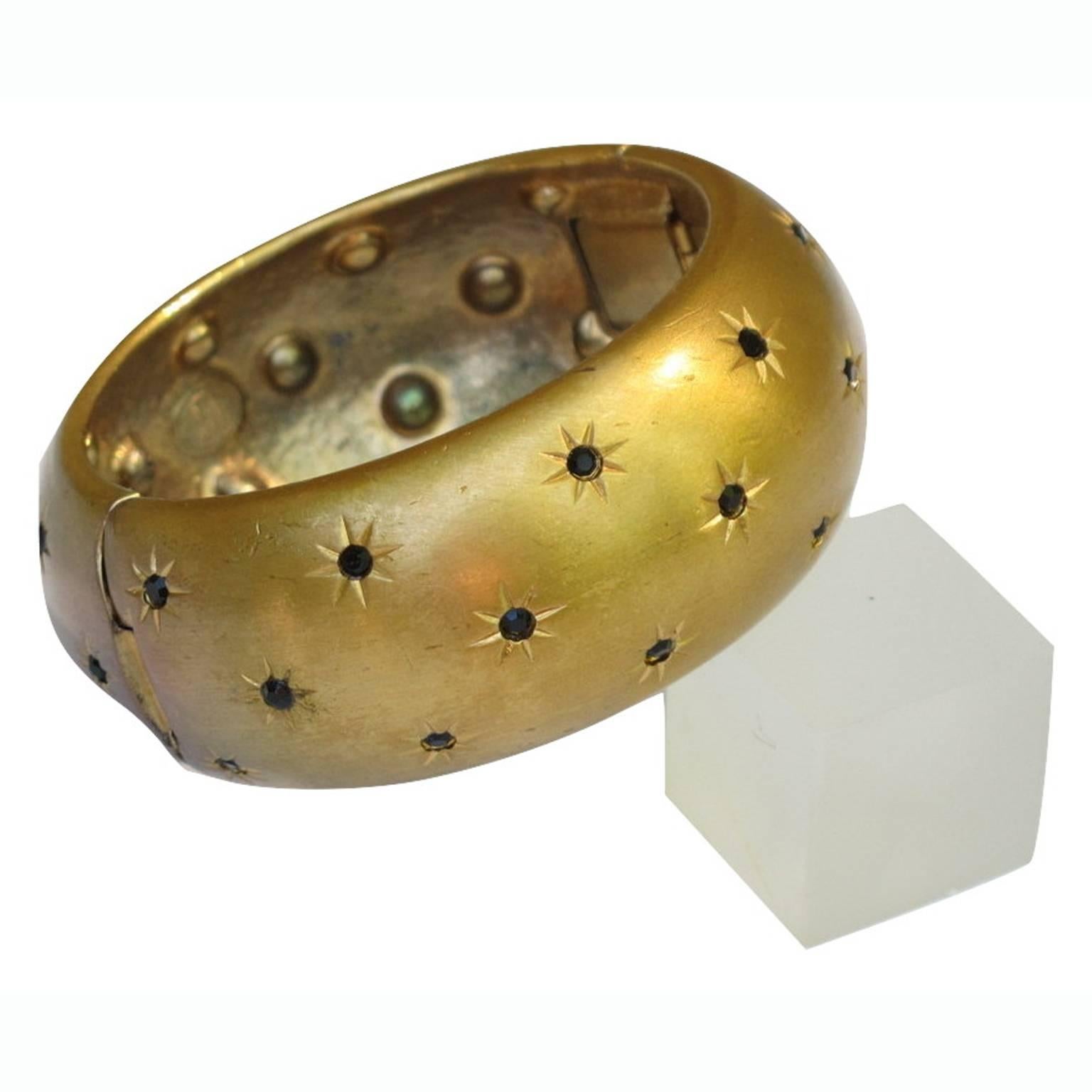 CHRISTIAN DIOR Paris Couture signed Clamper Bracelet. Rare 1960s original gilt metal domed shape with brushed finish aspect all covered with tiny carved stars ornate with black rhinestones. Signed in the inside with gilded tag: "Christian Dior