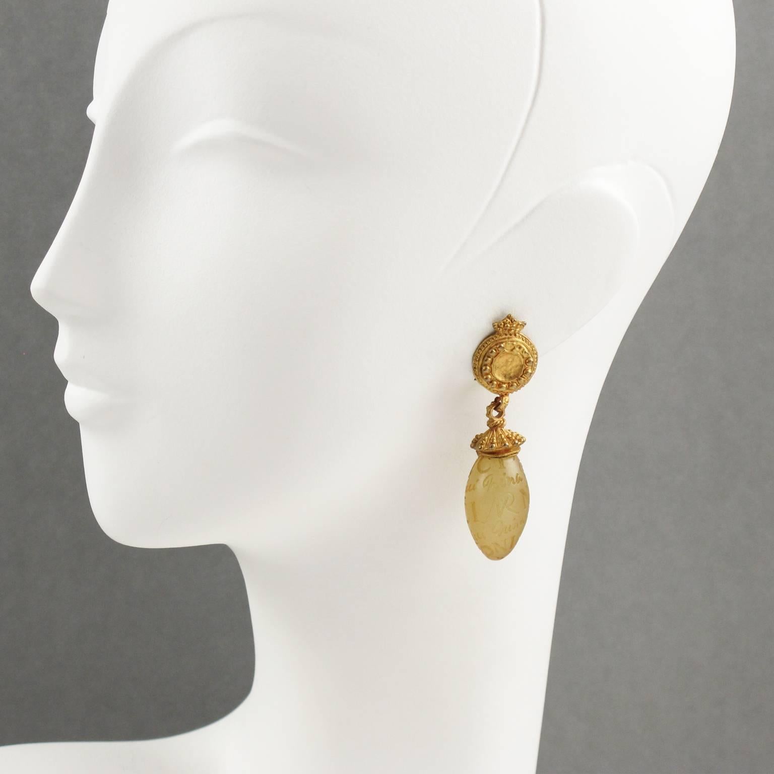 Lovely vintage 1990s Nina Ricci Paris signed dangling clip on earrings. Classic and beautiful jewelry piece, featuring tear drop shape with gilt metal all textured in a brushed finish aspect compliment with resin drop bead in translucent champagne
