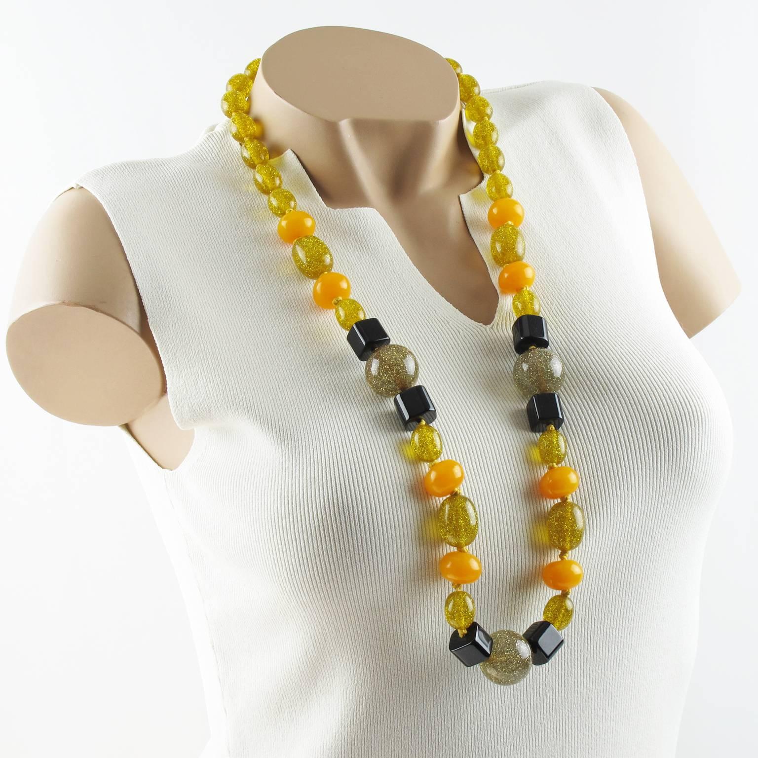 Extra long Bakelite and Lucite necklace. Assorted beads in various carved shape: round, olive, little square. Lovely mix and match of warm colors in assorted tones of black, orange tangerine, transparent gray and transparent yellow beads with