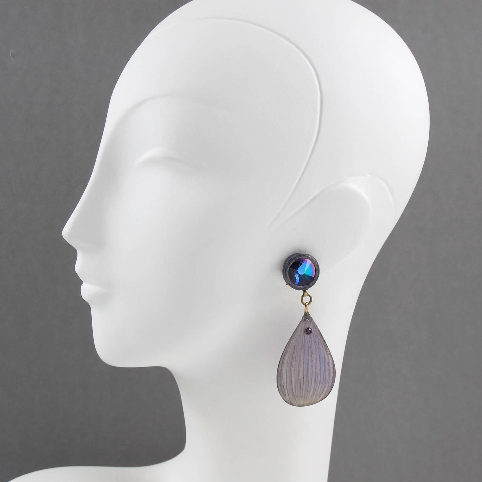 Lovely vintage Monique Vedie Talosel resin clip on earrings. Featuring floral dangling shape with carved dimensional large drop with textured pattern in light purple color, topped with large faceted glass cabochon in blue iridescent color. French