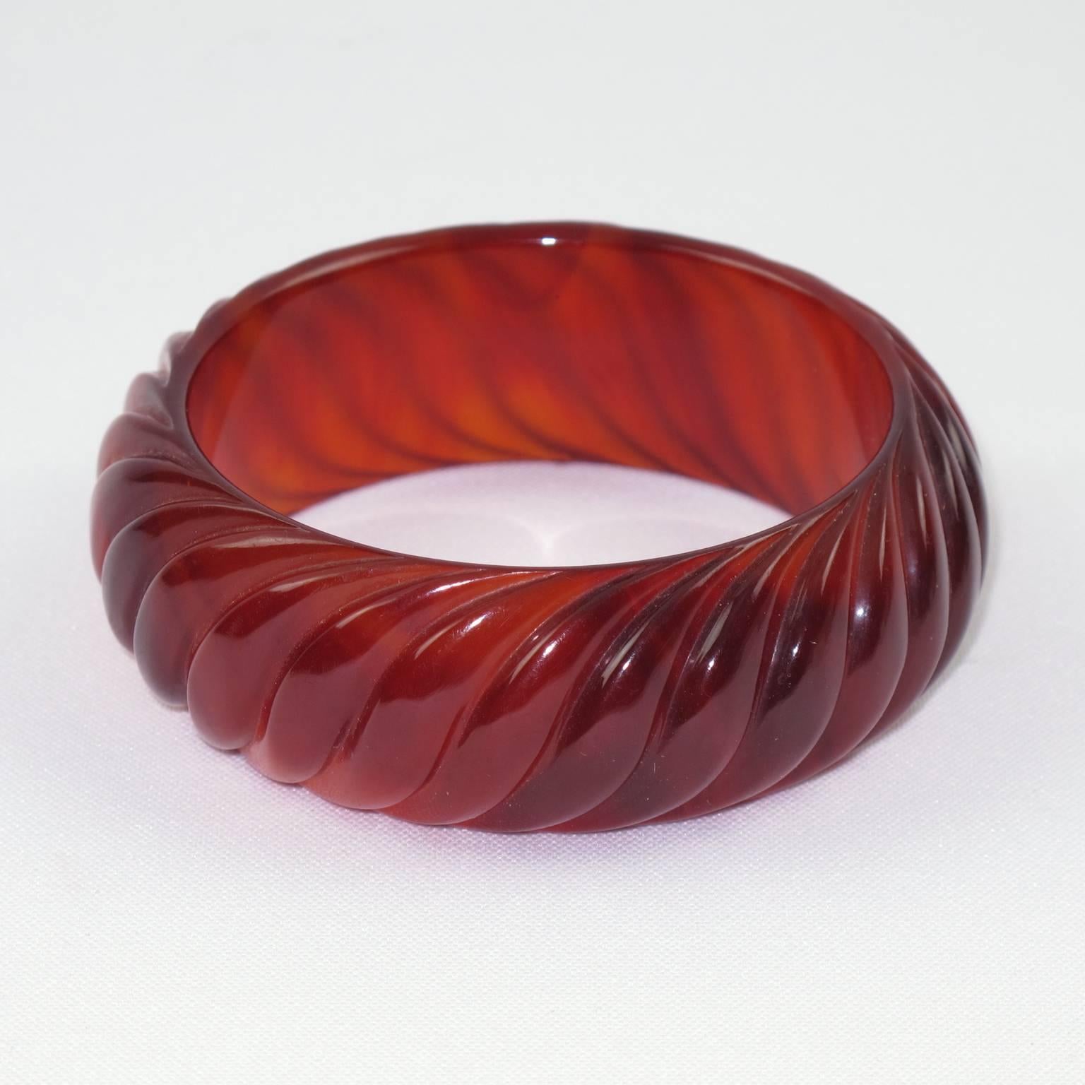 Vintage red tea amber marble Bakelite bracelet bangle. Chunky domed shape with deep geometric carved design all around and thick wall. Lovely red tea amber marble color with lots of translucency. Excellent vintage condition.  

Measurements: