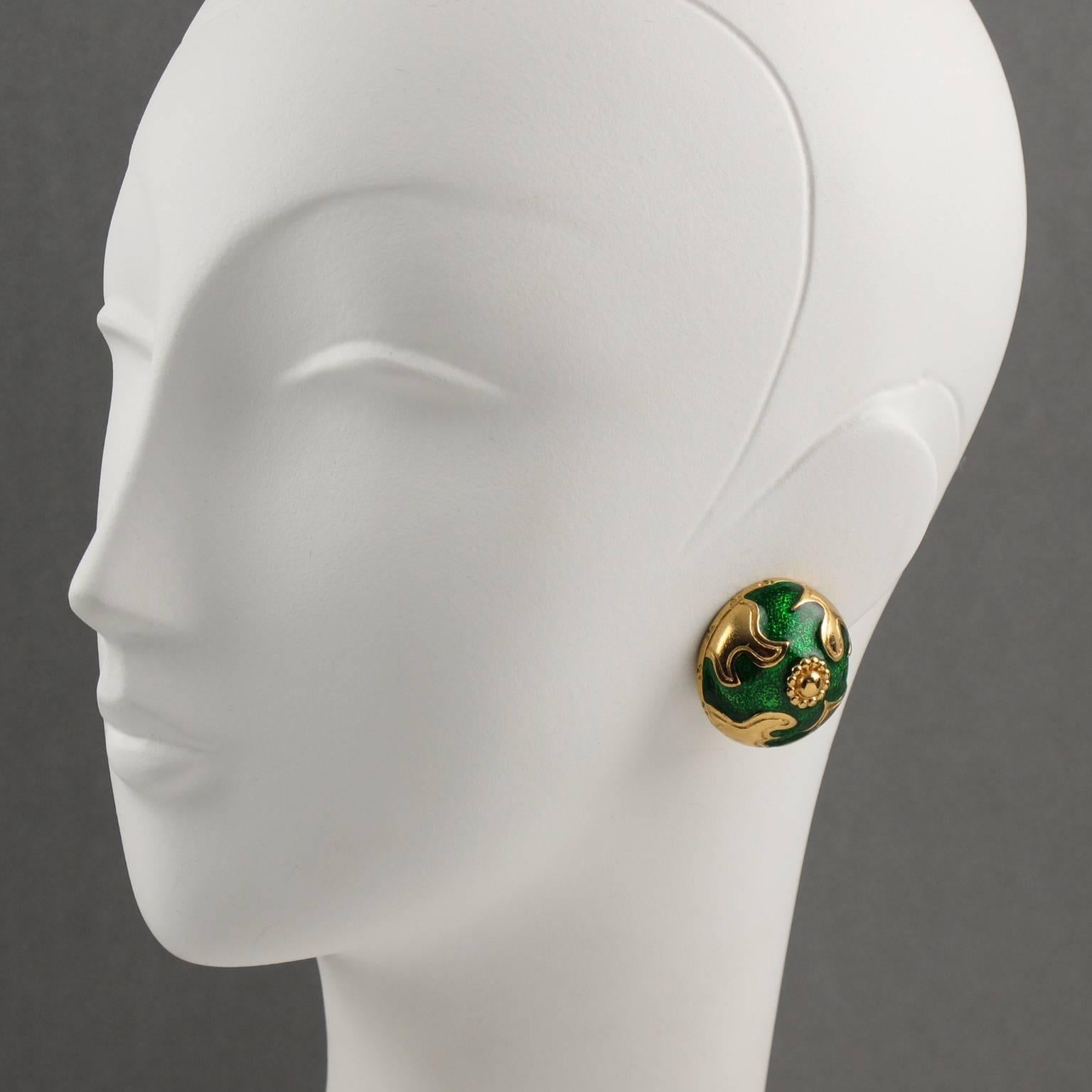 YVES SAINT LAURENT Paris signed clip on earrings. Baroque round domed shape, shinny gilt metal with texture ornate with emerald green enamel. Signed at the back with YSL pierced logo on clip and engraved underside: "YSL logo". Excellent