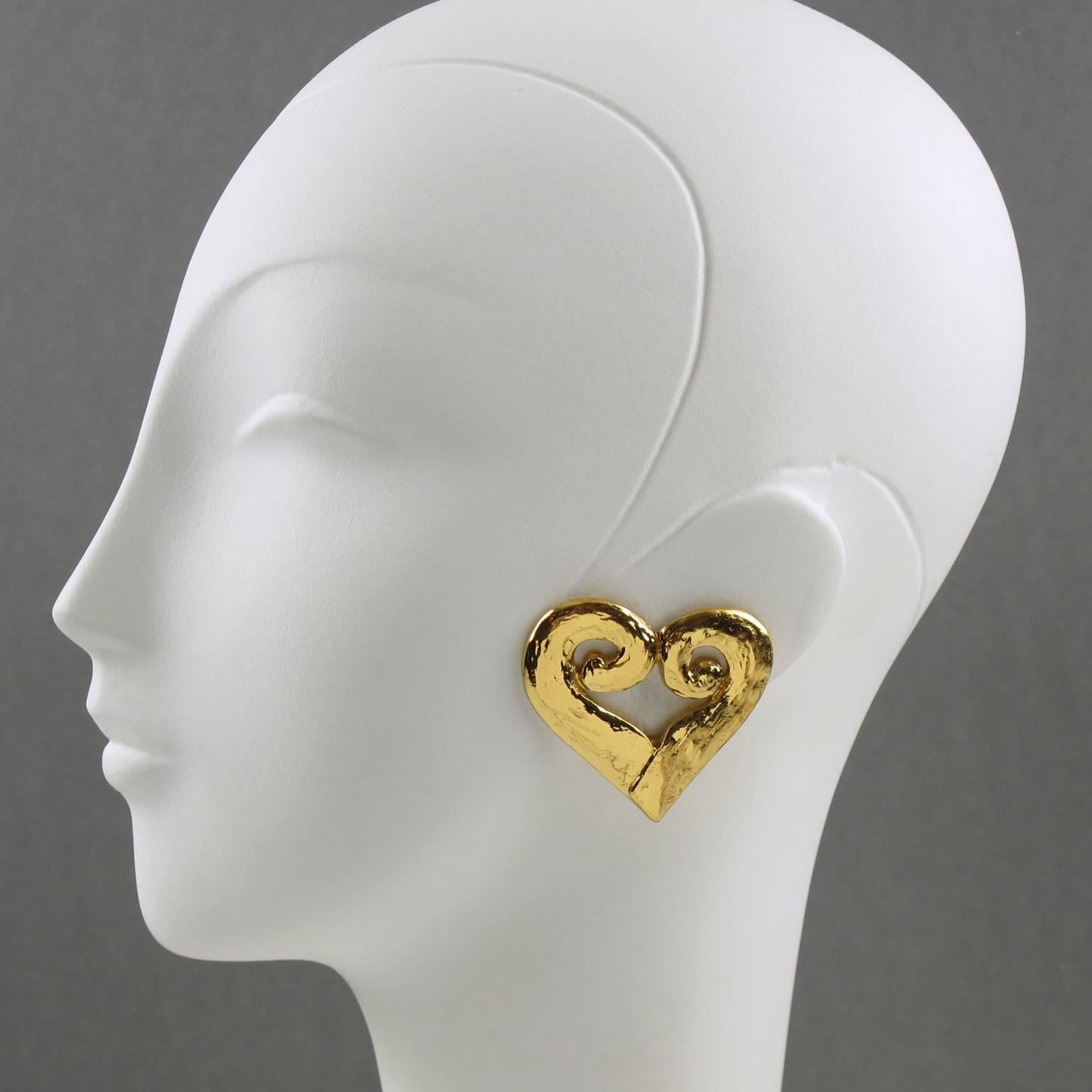 Vintage Yves Saint Laurent YSL Paris signed clip on earrings. Featuring lovely oversized gilt metal heart all carved and pierced with metal all textured. Marking underside with YSL logo pierced on clip and YSL Made in France tag logo. Excellent