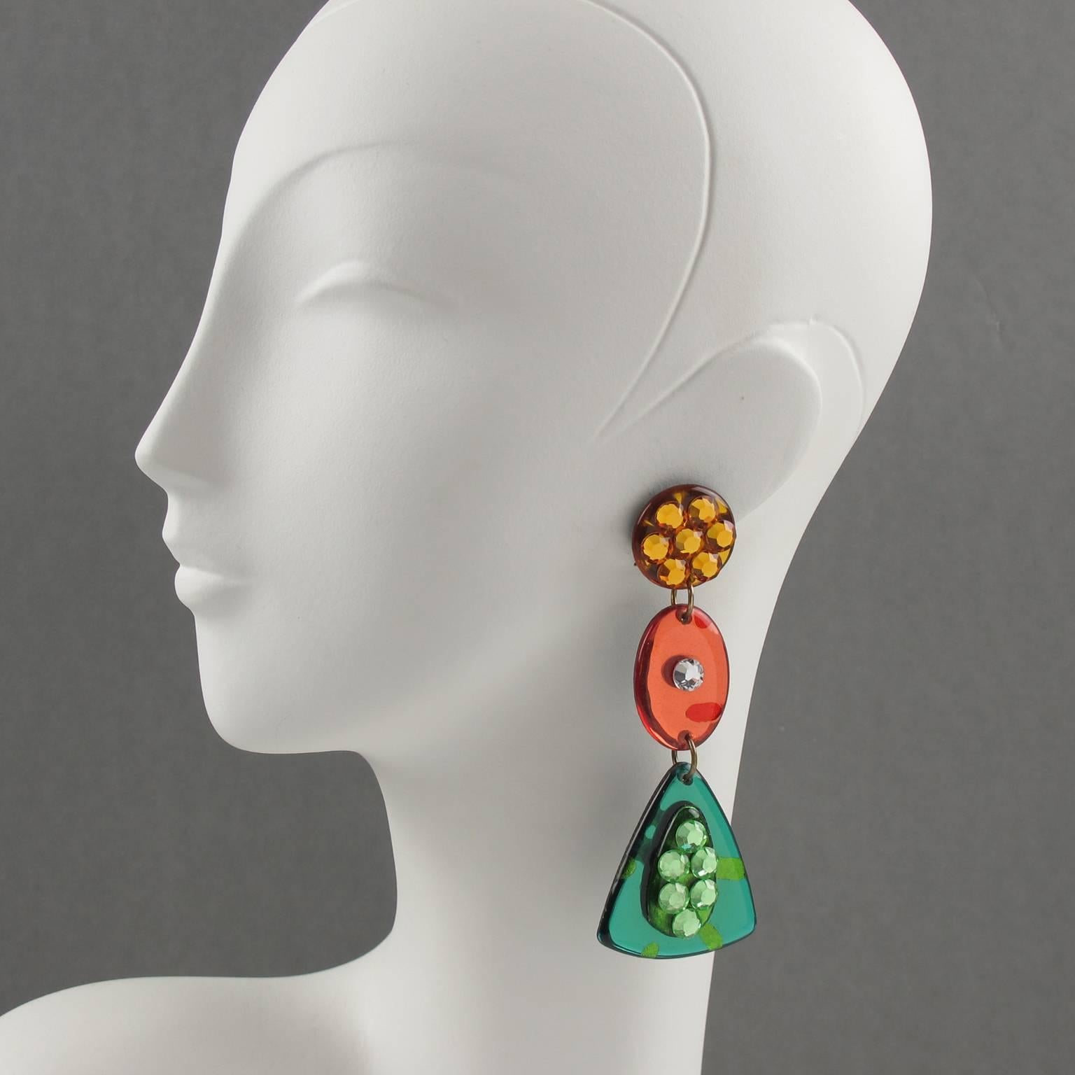Very cool Italian designer studio Lucite or Resin dangling clip on earrings. Oversized chandelier shape with geometric carved design in amber, neon orange and green colors with mirror effect and textured pattern. Earrings are also ornate with clear,