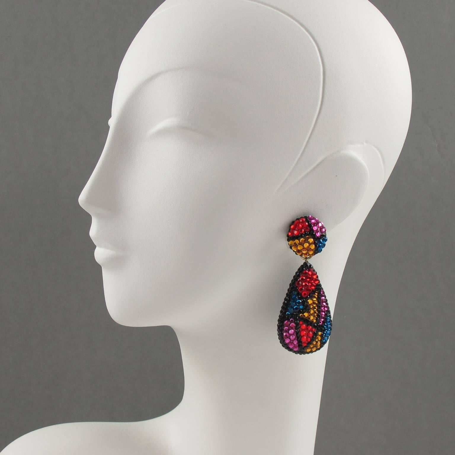 Fabulous statement clip on earrings designed by Richard Kerr in the 1980s. They are made up of his signature pave rhinestones. Featuring dangle geometric shape all covered with multicolor rhinestones. Assorted colors of red, amber, pink, blue and