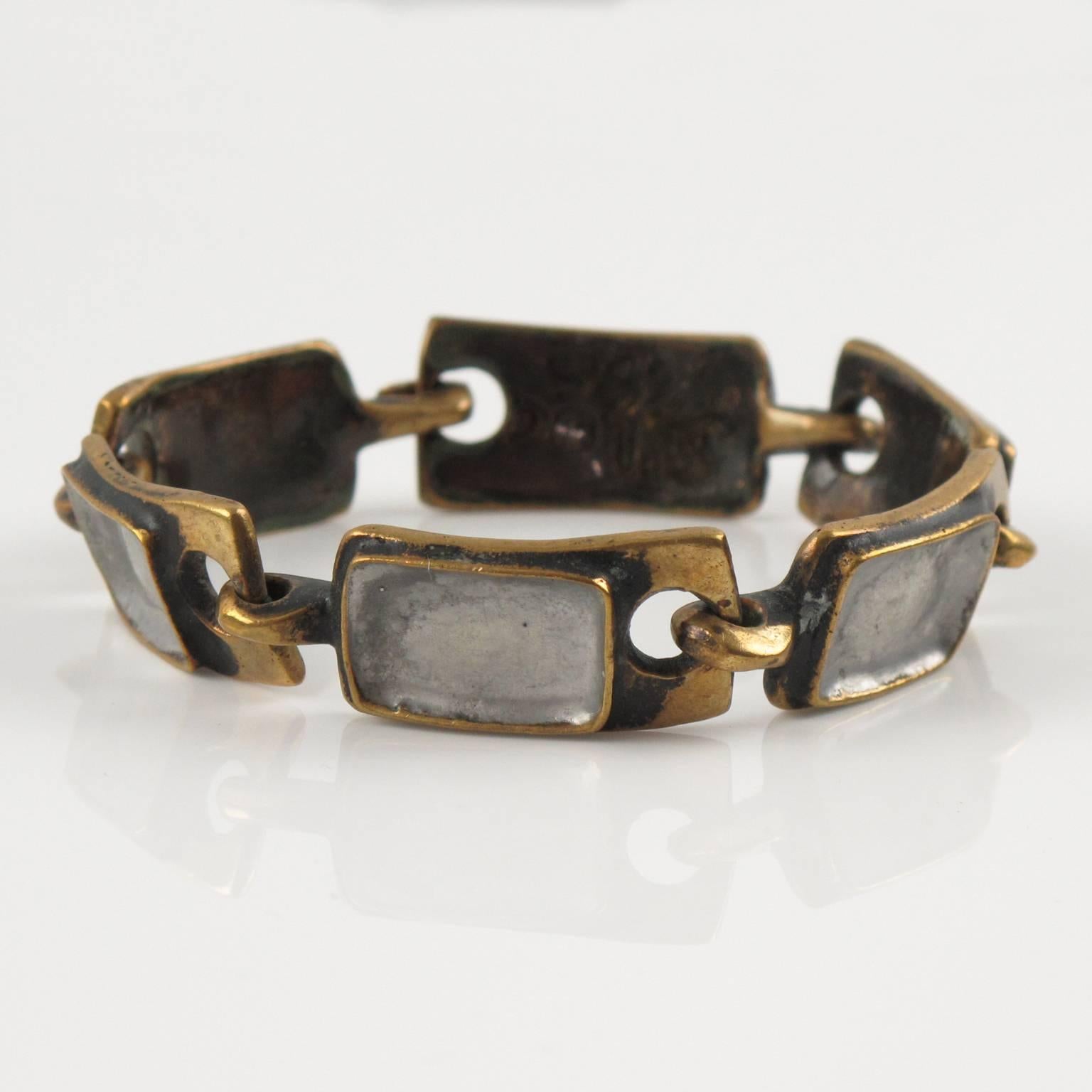 Rare modernist bronze and enamel link bracelet by French designer St Luc. Geometric gilded bronze metal carved elements topped with silver enameling. Hook closing clasp. Signed underside: 