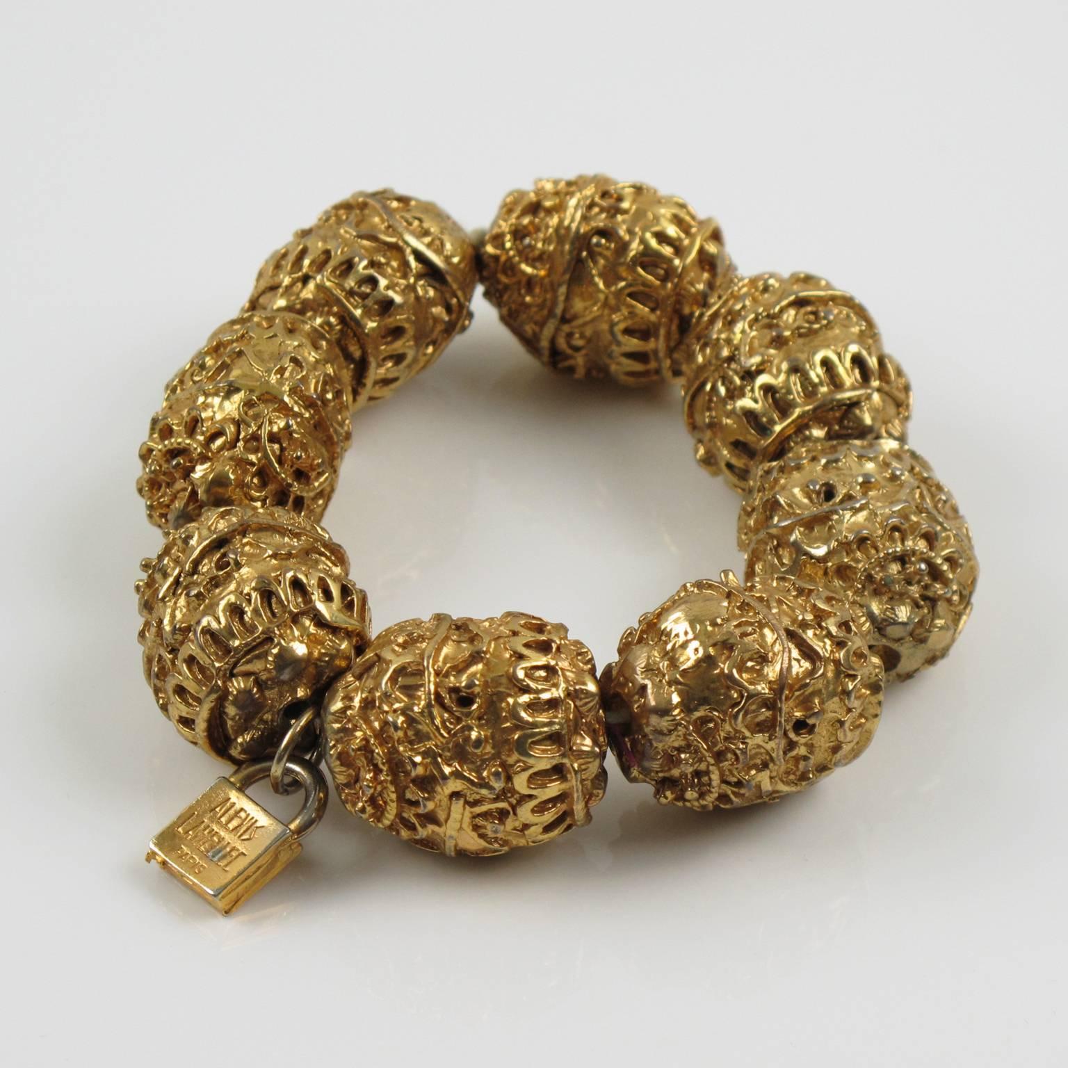 Rare French designer Alexis Lahellec Paris signed stretch bracelet. Unusual piece featuring eight large gilt metal coated resin carved beads, all textured and ornate with a baroque inspired design. Although beads are resin coated with gilt metal the