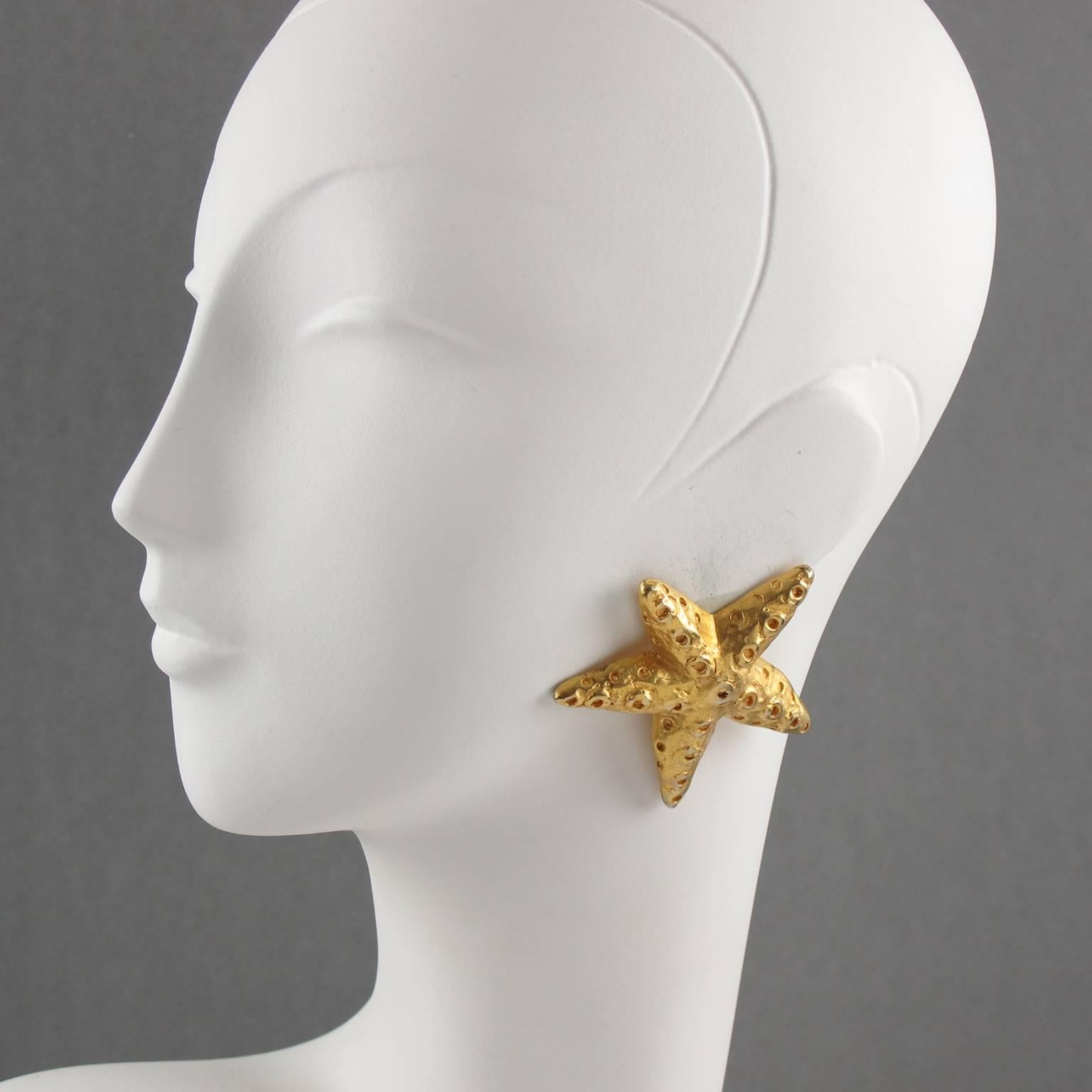 Lovely Christian Lacroix Paris signed clip-on earrings. Featuring oversized dimensional starfish in shinny gilt metal with textured and carving. Brand tag logo underside.
Measurements: 2.44 in. wide (6.2 cm) x 2.25 in. high (5.7 cm)