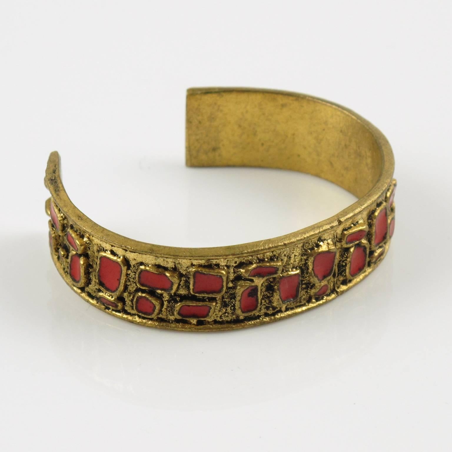 Rare Mid-Century modern bronze cuff bracelet. Gilt bronze band topped with geometric design ornate with bright red enameling. 
Measurements: Inside across = 2.32 in. x 1.75 in. (5.9 x 4.5 cm) - Opening = 1.44 in. (3.6 cm) - Band width = 0.63 in.