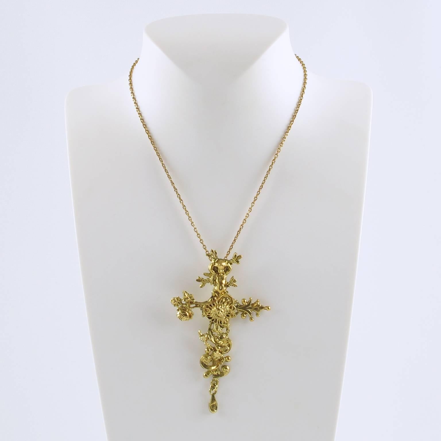 Vintage 1990s Christian Lacroix Paris rare gilt metal pendant necklace featuring a gorgeous detailed and textured cross with dangling charm, topped with a cherub, a heart and the allegorical portrait of the King Louis XIV, founder of the Comedie