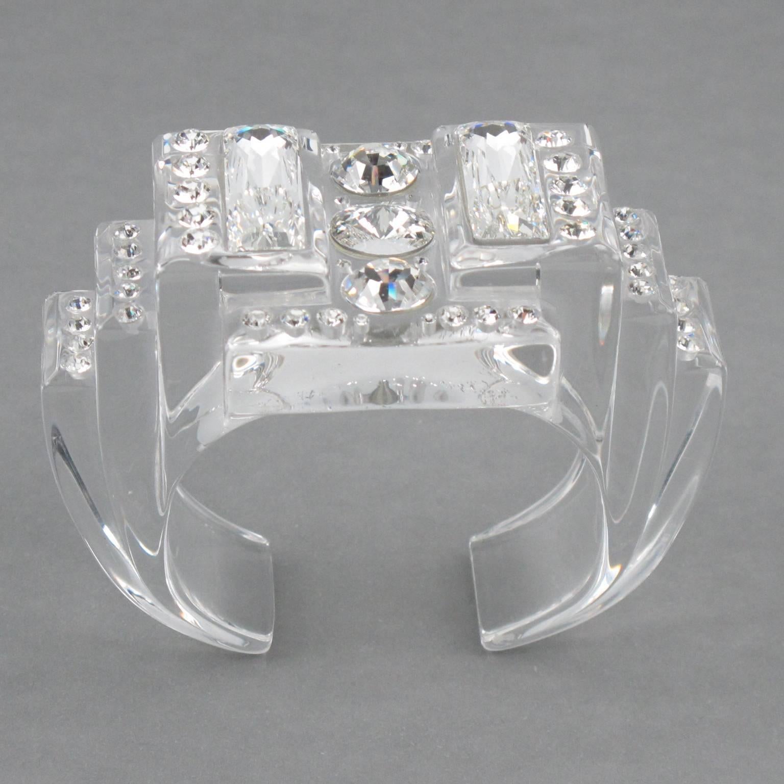 Gorgeous Christian Dior Paris signed Lucite bracelet. Crystal clear Lucite sculptural cuff shape embellished with glittering clear Swarovski crystal cut rhinestones. Embossed "Dior" logo on both side. Excellent condition.

Measurements: