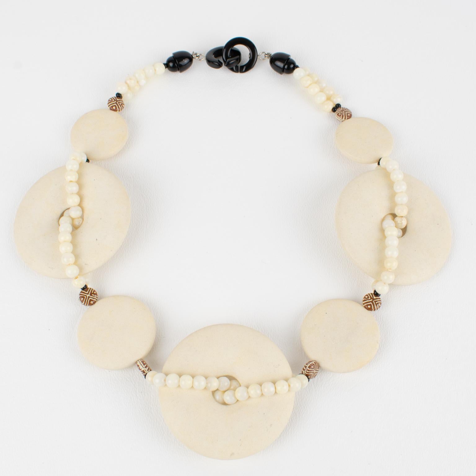 Ce superbe collier ras-de-cou Angela Caputi a été fabriqué en Italie. La pièce présente un design d'inspiration moderniste avec des éléments géométriques en résine. Les trois grandes perles donut arrondies sont légèrement bombées et présentent une