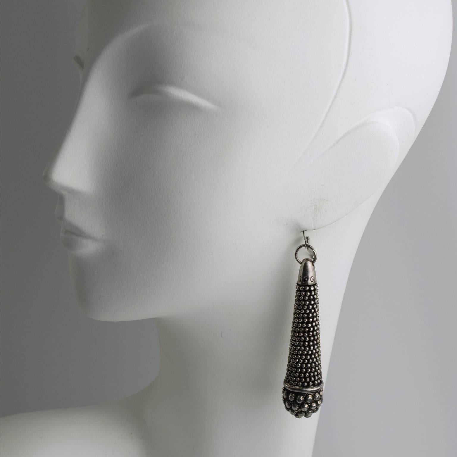 Rare oversized dangling ethnic inspired earrings by French couture designer Jean Paul Gaultier. Featuring long tubular form in silvered metal with aged patina and bead pattern design. For pierced ears. Engraved 'JPG' logo on top of each earring.