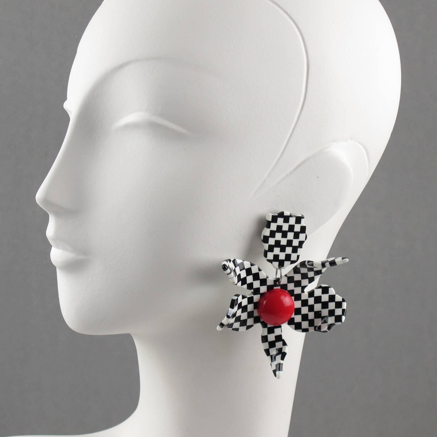 Stunning oversized lucite clip on earrings designed by Harriet Bauknight for Kaso. Dimensional large flower with black and white checkerboard pattern and huge red half bead center. Unsigned but specific clip back and design are unmistakable brand