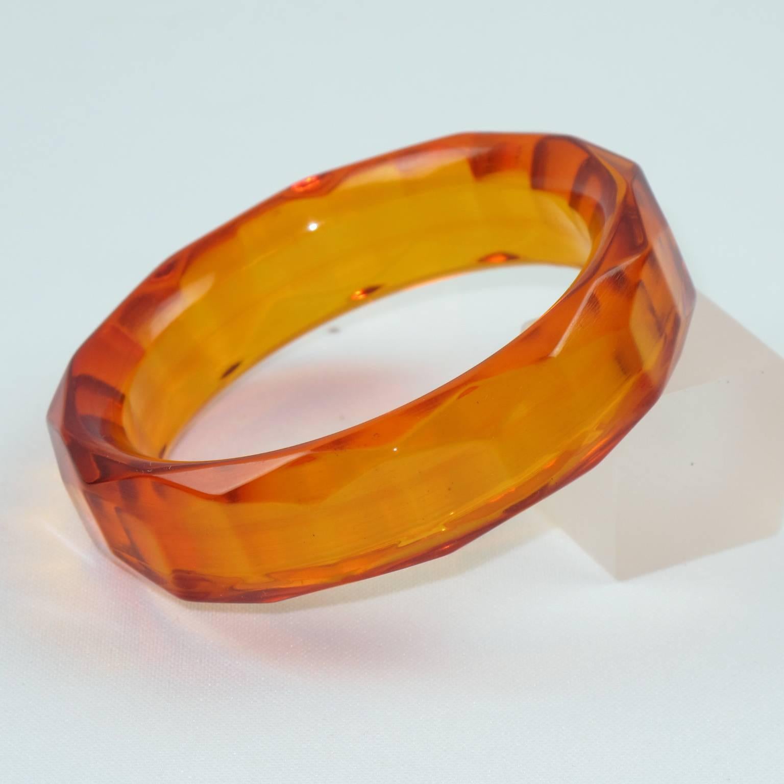 Stunning transparent orangeade Bakelite bracelet bangle. Chunky sliced shape with deeply faceted and carved design all around and extra thick wall. Intense orangeade tone, all transparent orange color with red overtone on edges. This Prystal quality