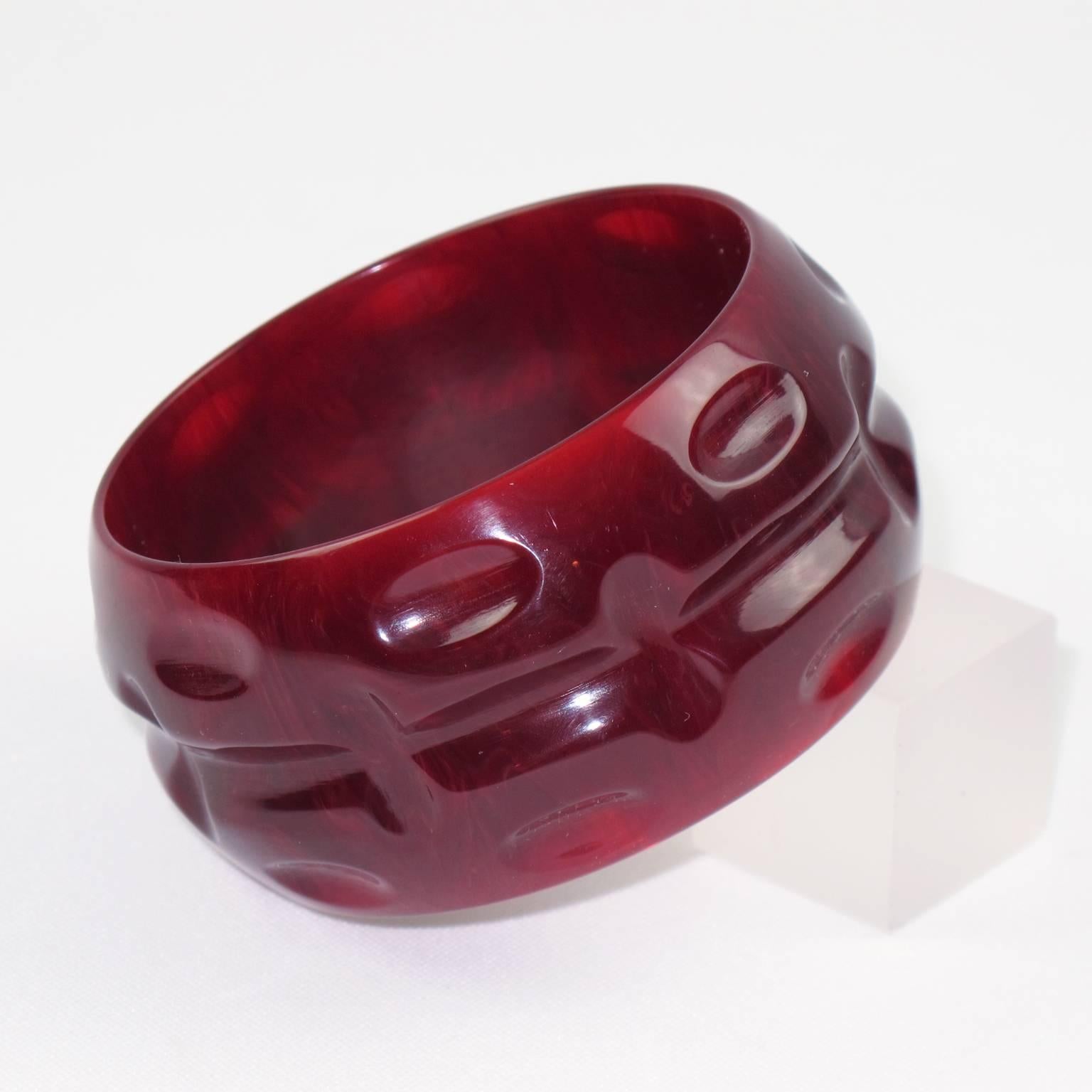 Stunning sangria red marble Bakelite bracelet bangle. Chunky domed oversized shape with unusual deep geometric carving all around. Intense red marble tone with cloudy swirling and translucency. 
Measurements: Inside across 2.57 in. (6.5 cm) -