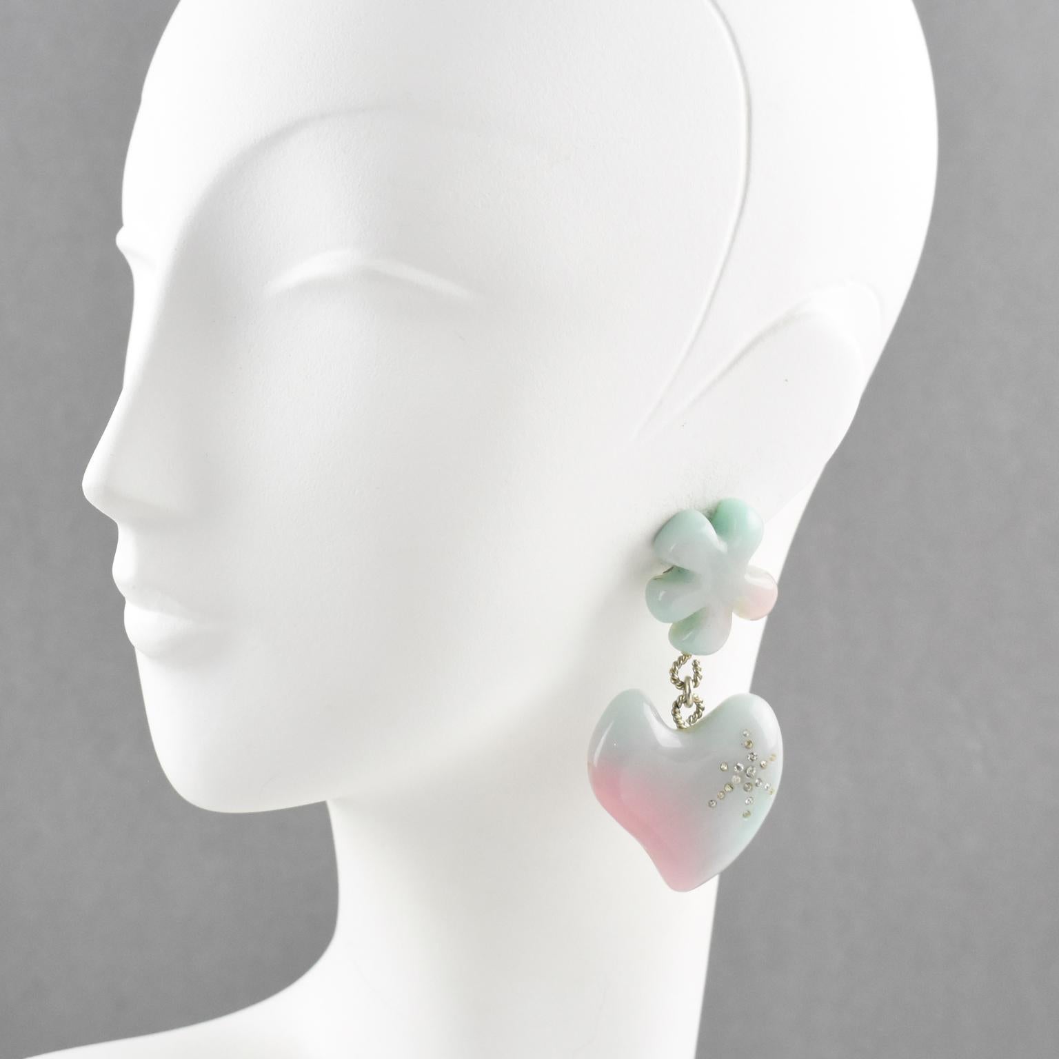 Lovely Christian Lacroix Paris signed clip on earrings. Oversized pastel colors (green and pink marble) resin dangling shape, featuring abstract flower and heart ornate with crystal clear rhinestones. Silvered metal hardware. Signed on gilded tag at