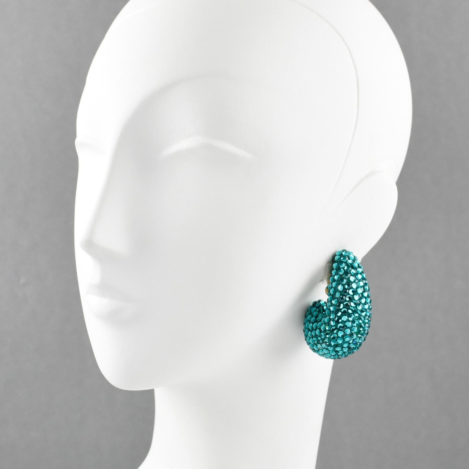 Elegant statement clip on earrings designed by Richard Kerr in the 1980s. They are made up of his signature pave crystals. Featuring nautilus shape all covered with turquoise color rhinestones. Marked at the back with designer tag