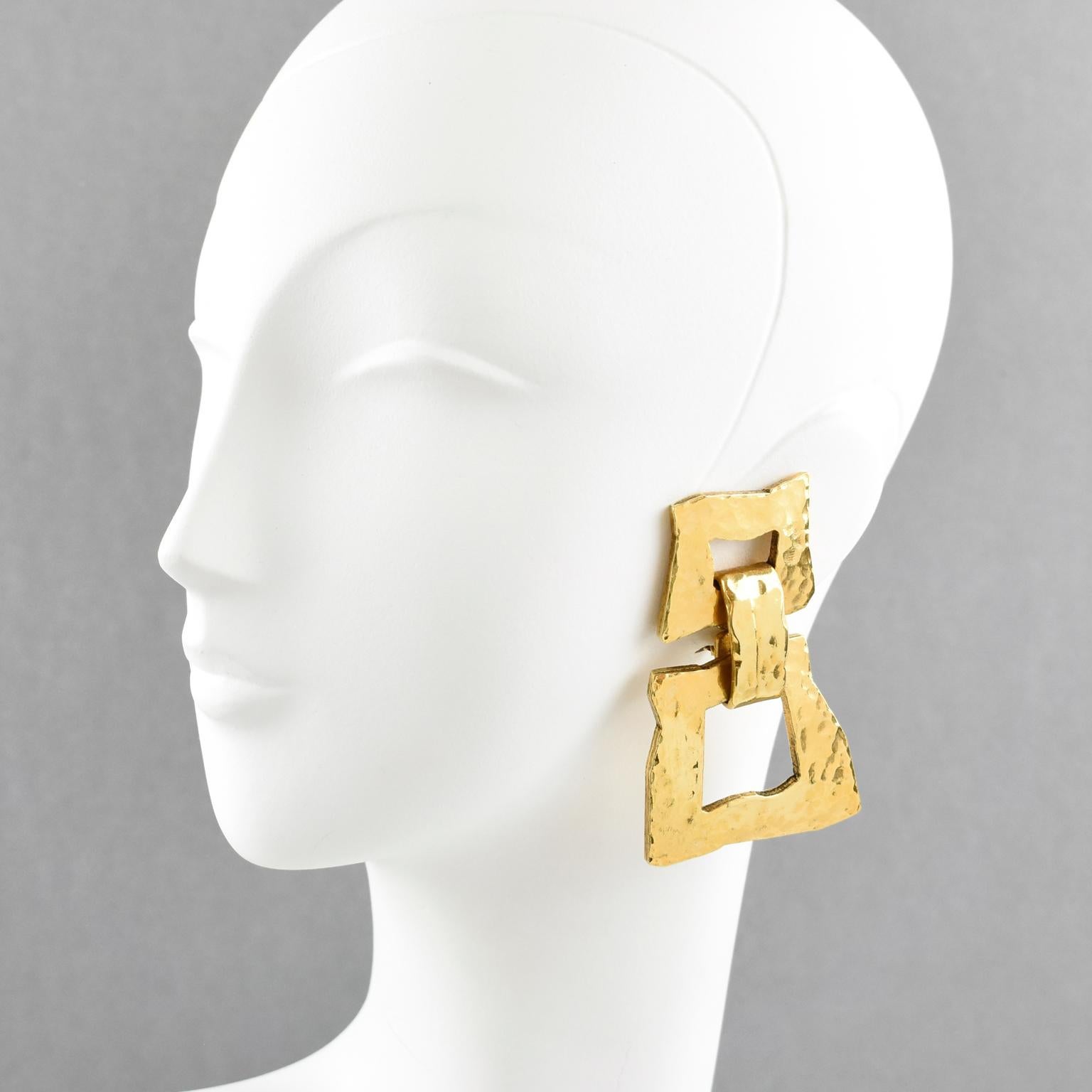 Very chic Mercedes Robirosa Paris signed clip on earrings. Fabulous oversized modernist style with dangling geometric shape and gilt metal all textured and lightly hammered. Signed at the back with brand tiny logo.
Measurements: 3.07 in. long (7.8