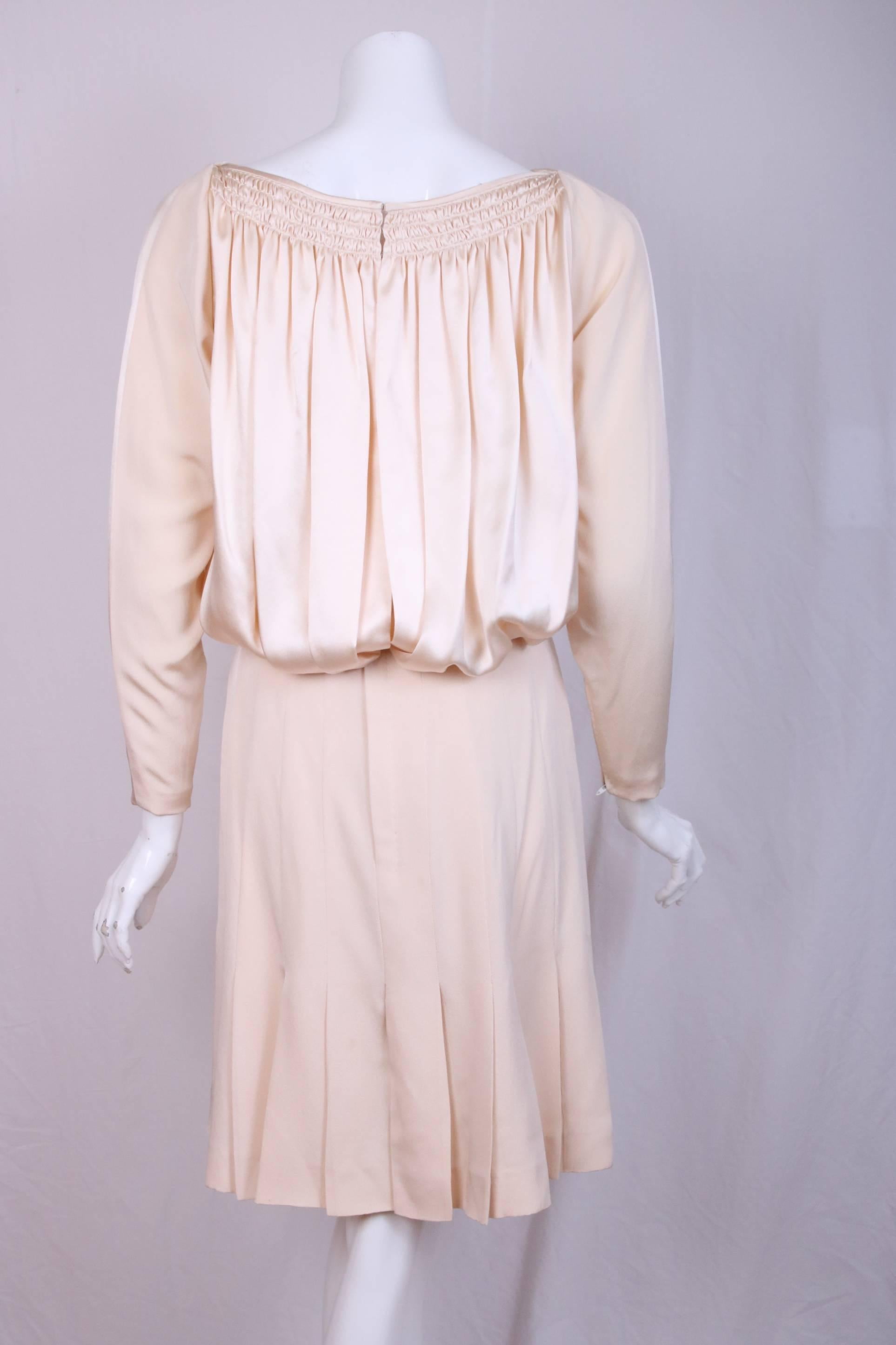 Vintage Galanos silk charmeuse & silk twill cocktail dress. The top is done in silk charmeuse with 3 rows of delicate smocking that create soft gathers that cascade to create a blouson effect. The skirt is pleated silk twill that falls just above
