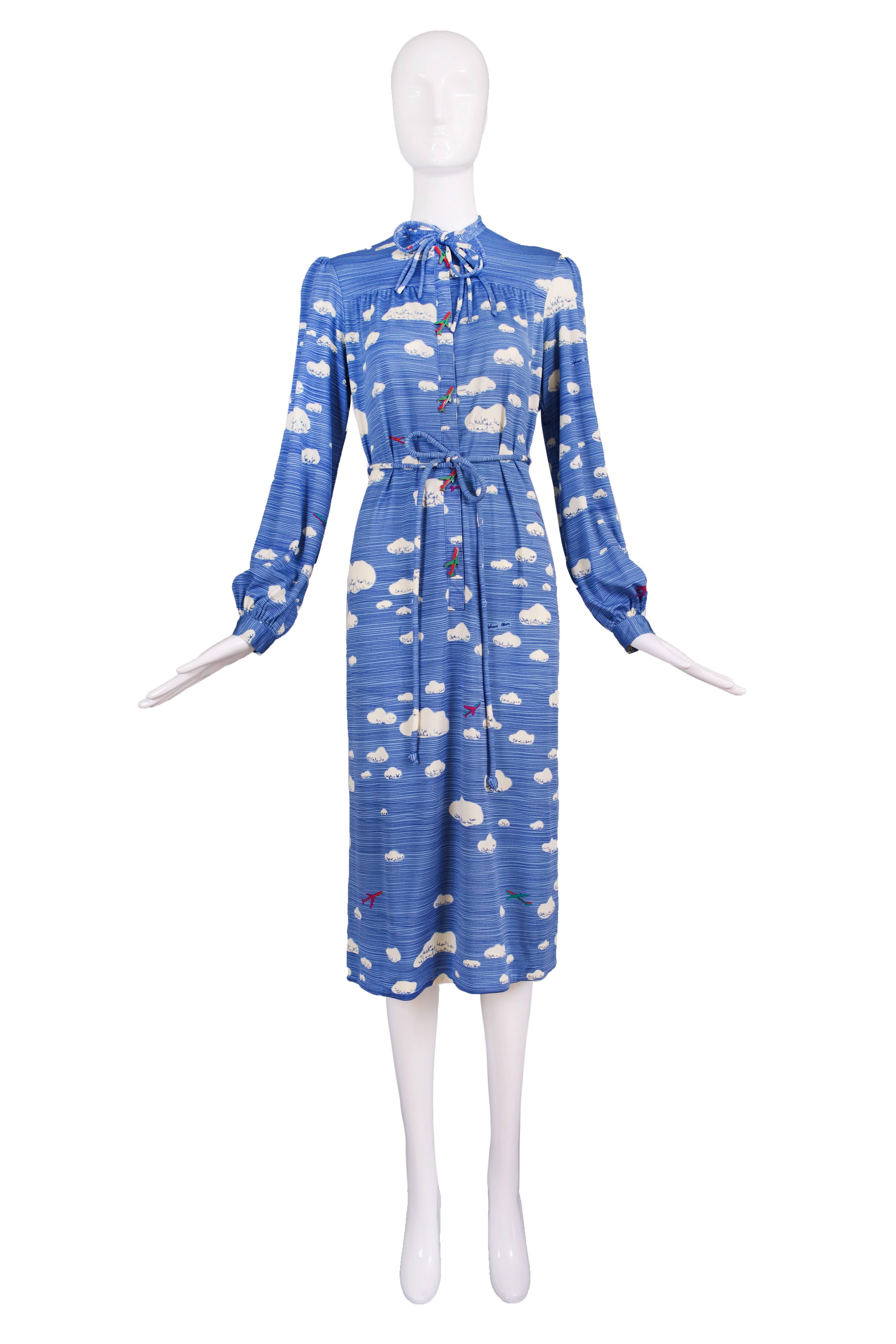 Vintage Hanae Mori nylon day dress with neck ties, self waist tie, side pockets and featuring a cloud and airplane print with bakelite airplane buttons. Size tag L. In excellent condition.
MEASUREMENTS:
Shoulders - 15