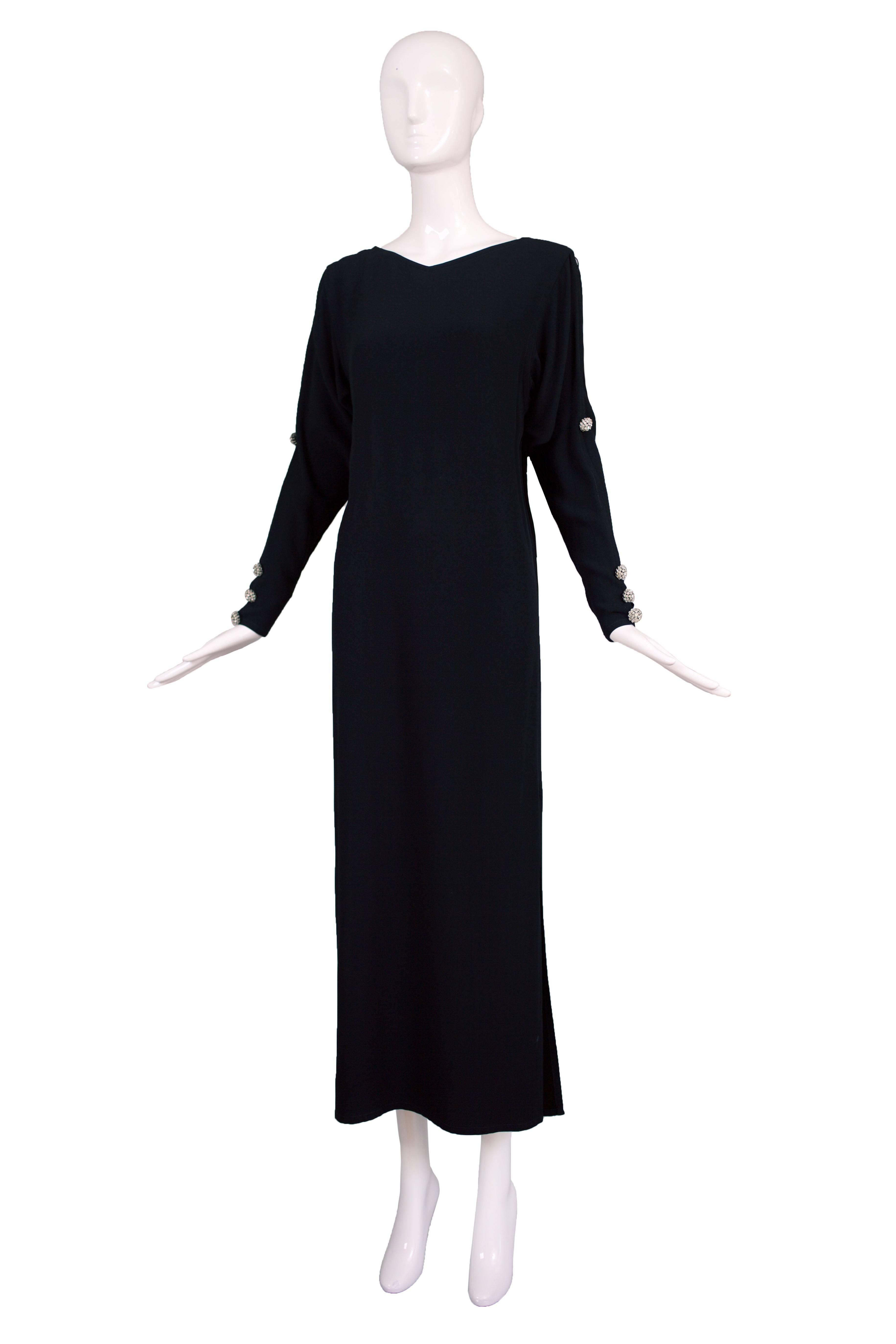 Late 1970's/early 80's Yves Saint Laurent black silk crepe evening gown with long sleeves, slits up both sides and decorative crystal buttons at the arms and sleeves. In excellent condition. Tag size 42. Please consult measurements.