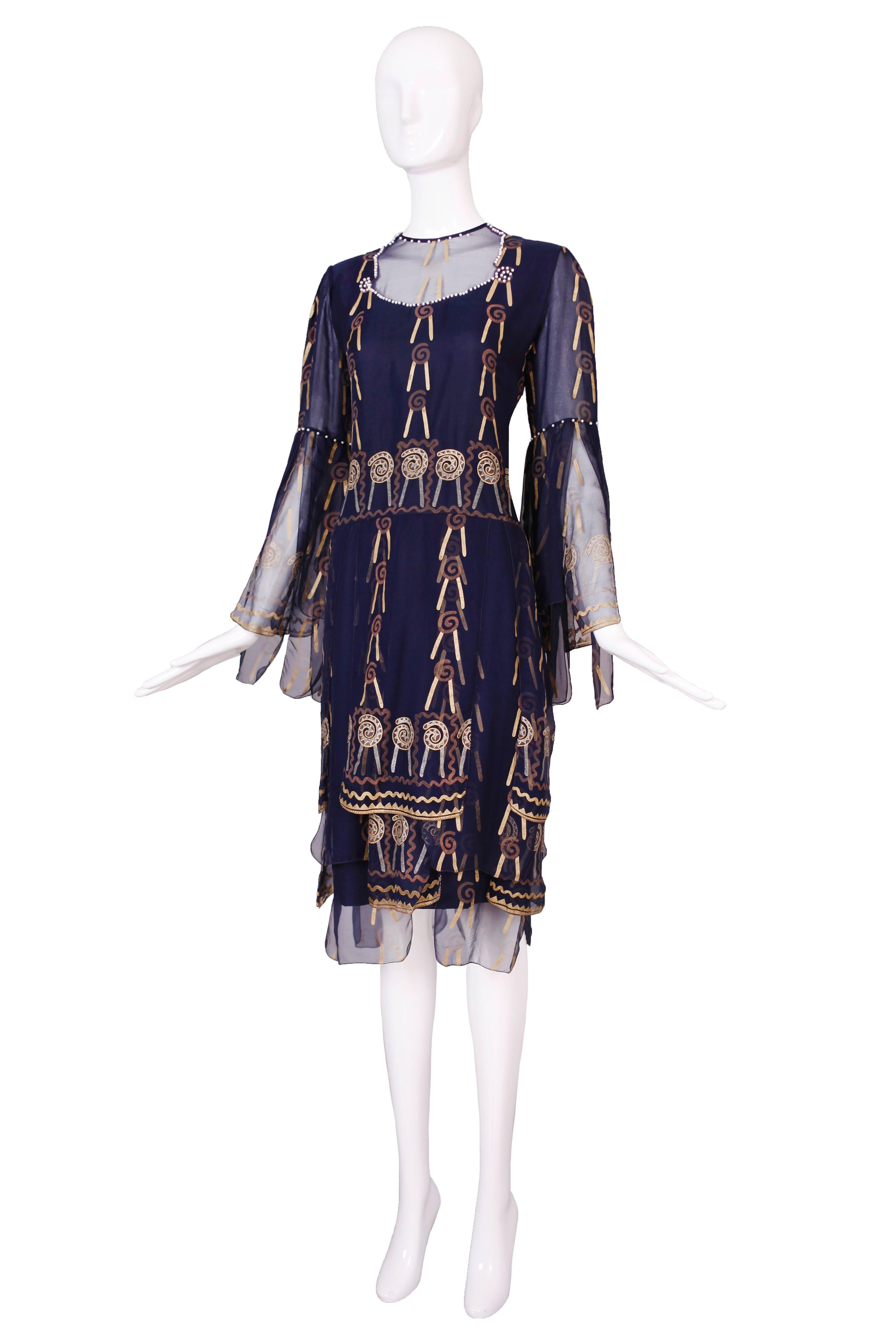 Zandra Rhodes navy blue hand-painted drop-waisted dress with decorative panels and embroidered pearls are the neckline and arms. In excellent condition. Size tag 8. See measurements.
MEASUREMENTS:
Bust - 38