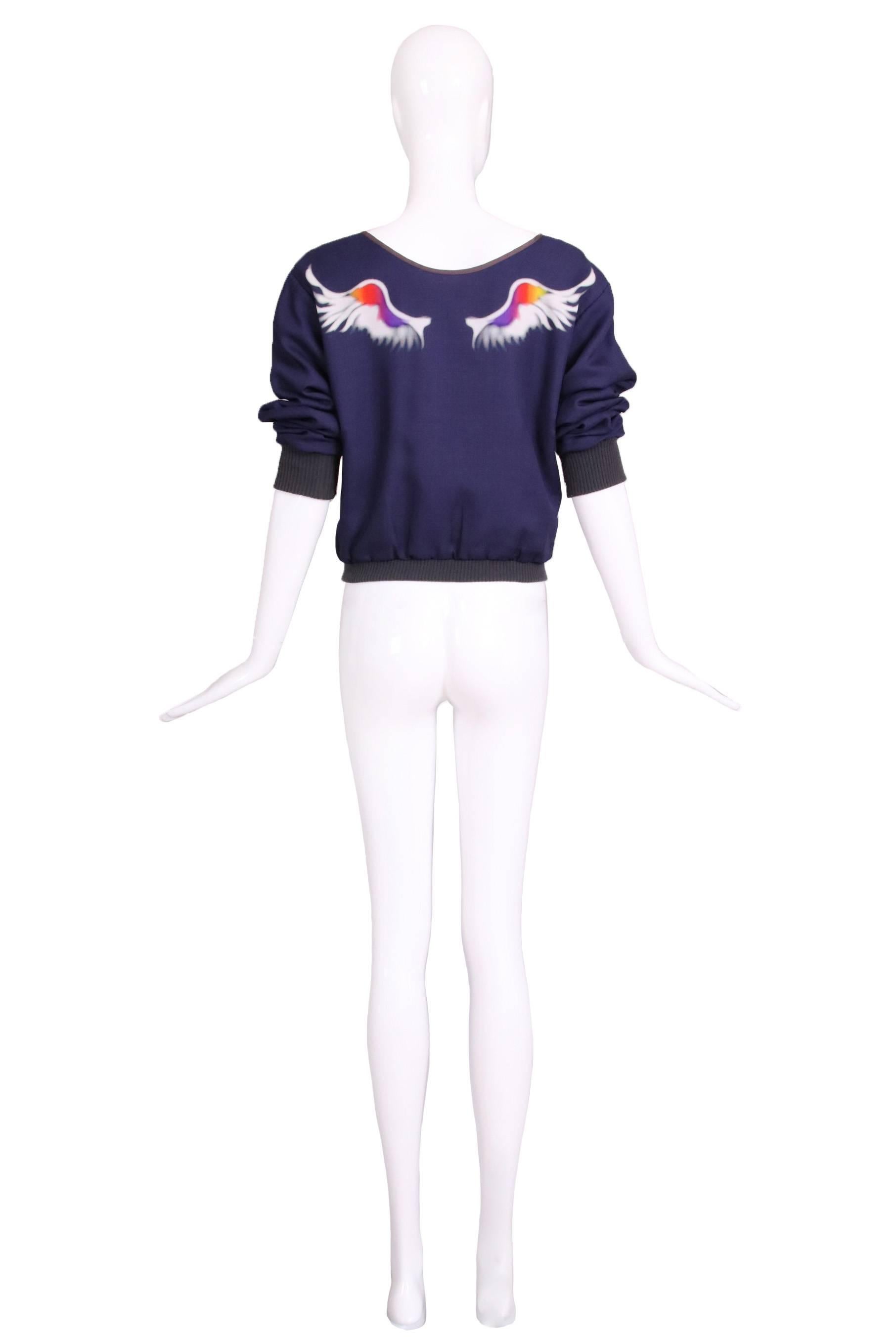 Veste zippée bleue de Yohji Yamamoto avec des liens à l'intérieur pour resserrer la taille et une paire d'ailes en blanc, rouge, orange, jaune et violet imprimée dans le dos. En excellent état. 100% polyester. Taille 1.
MESURES :
Poitrine -