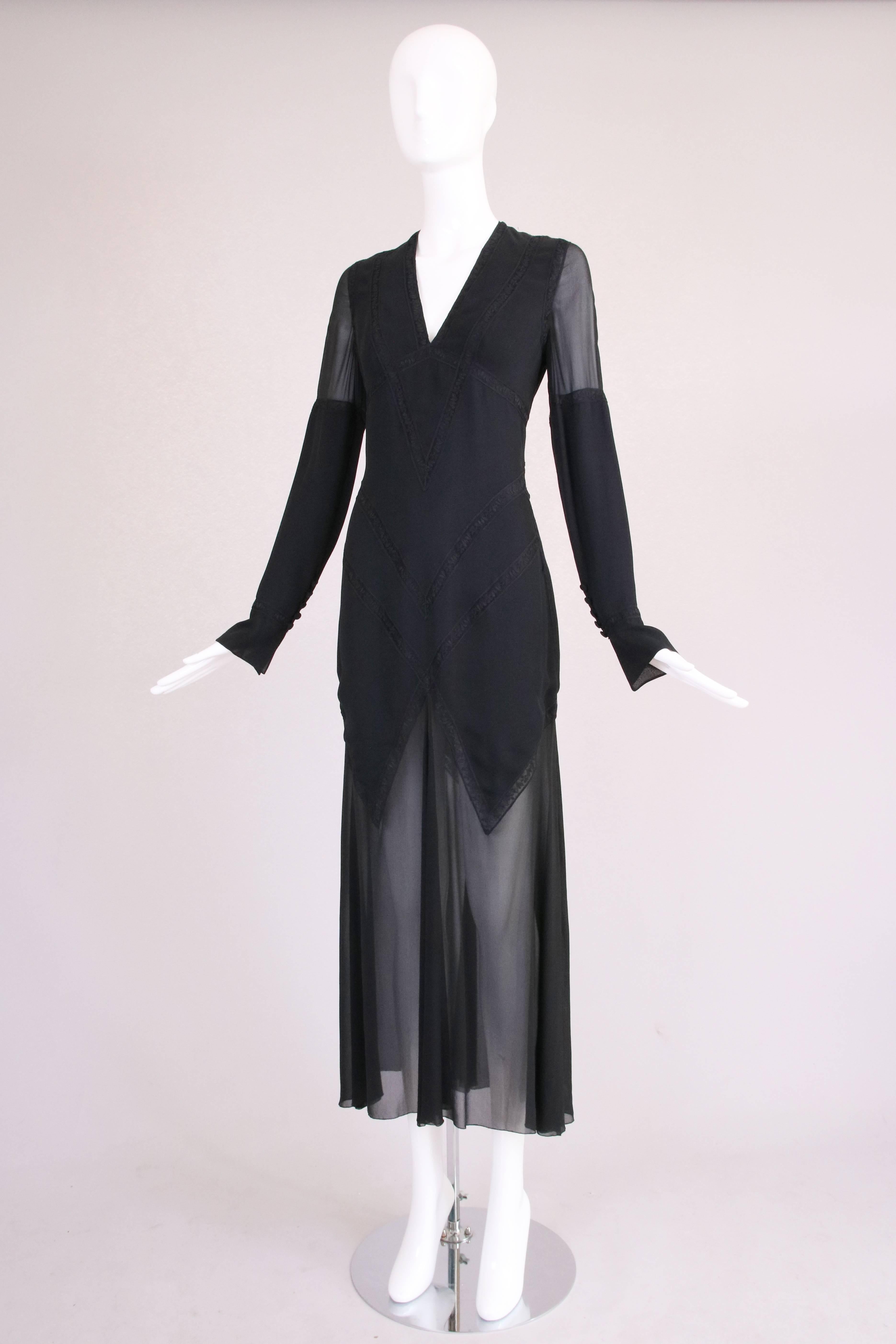 1980’s Karl Lagerfeld long-sleeved black silk evening dress with transparent chiffon lower skirt and upper arms, diagonal lace insets, deep v-neck and deep keyhole opening at the back and button closure at the lower back. Size tag