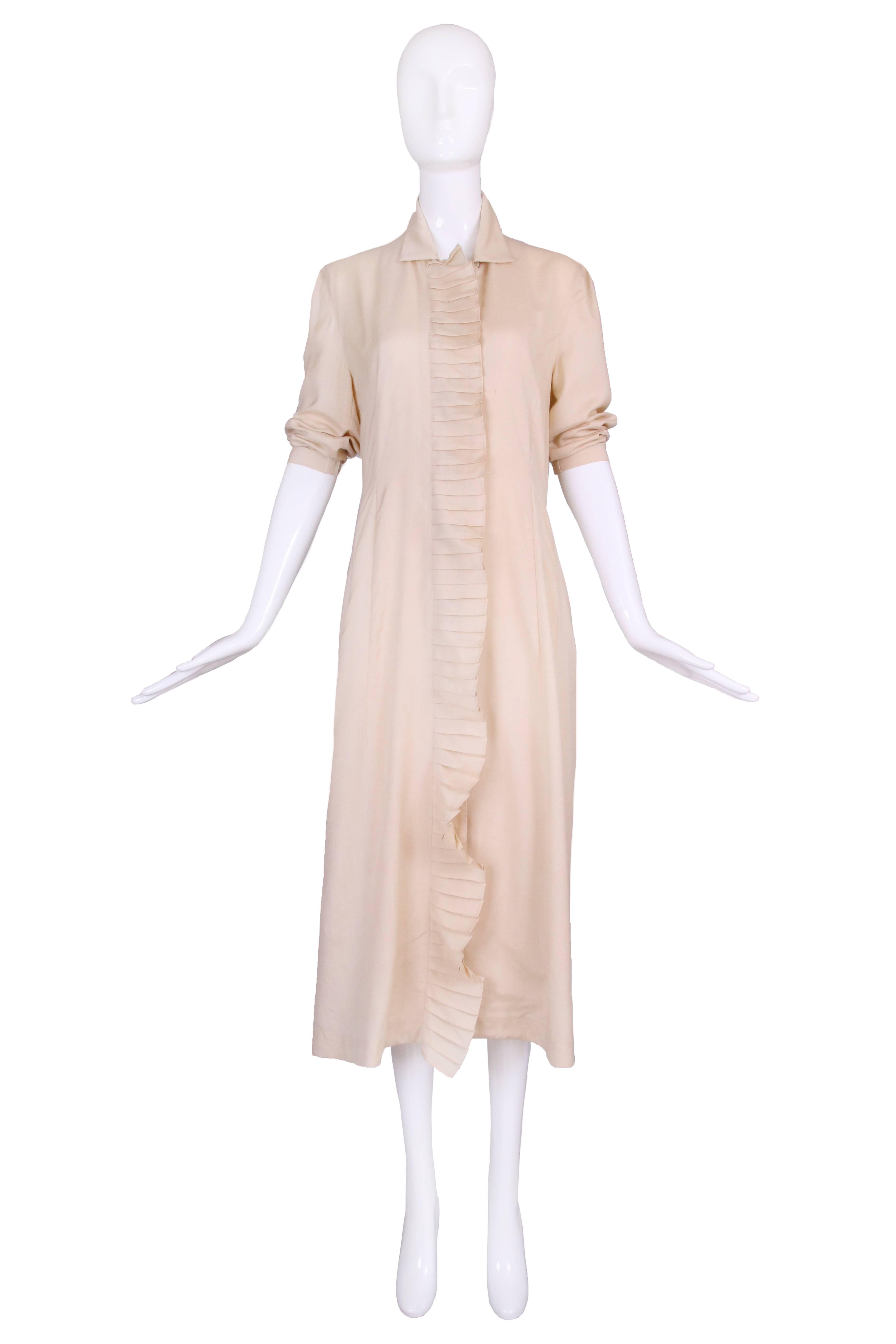 Matsuda creme colored silk and wool blend overcoat/dress coat with oversized button closure at the front and geometric ruffled trim that continues at the bottom hem, round to the back and forming an opening at center back hem. In excellent condition