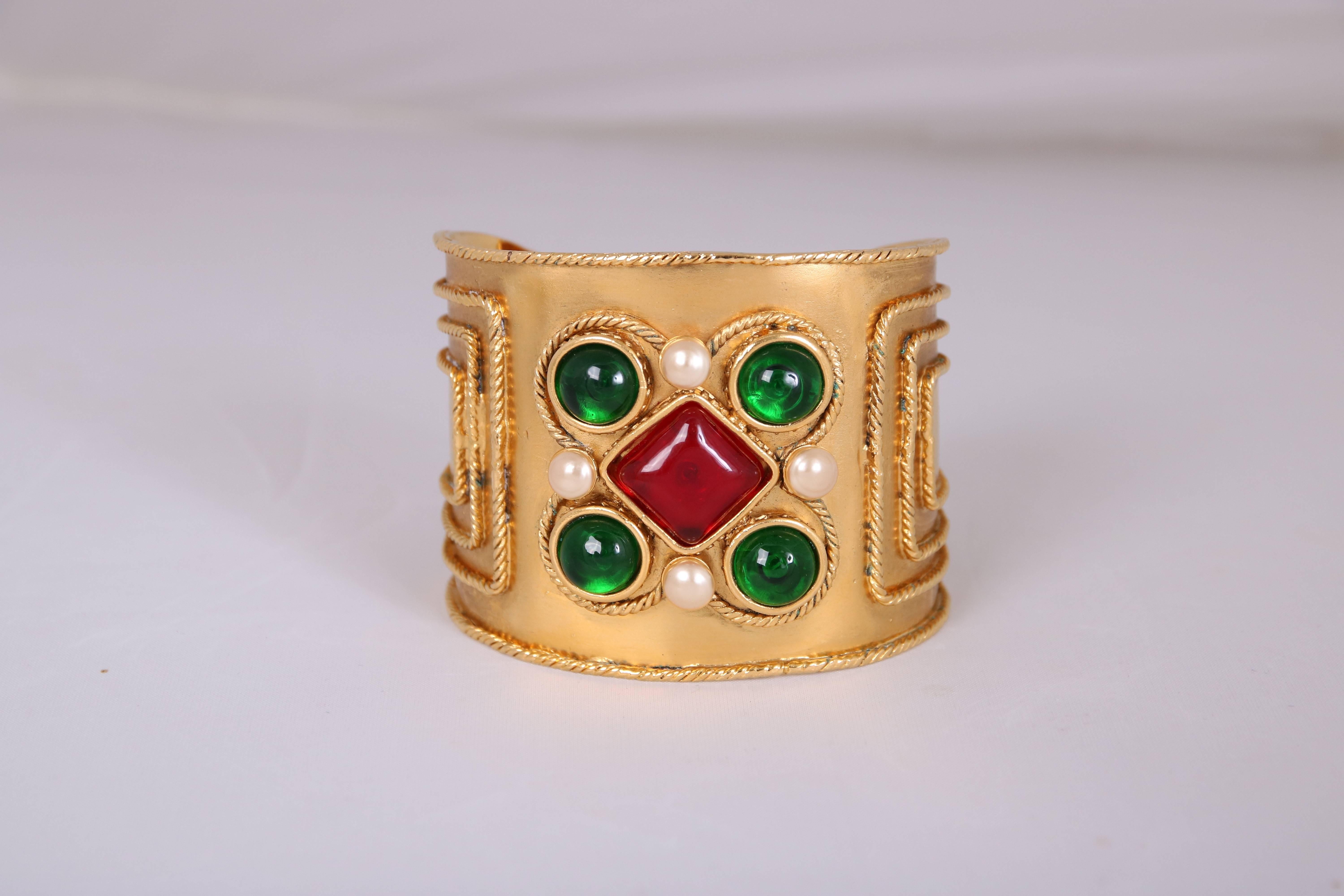 2005 Chanel cuff featuring bezel set pearl beads and green and red gripoix stones. Stamped on Chanel cartouche at interior. In excellent condition.