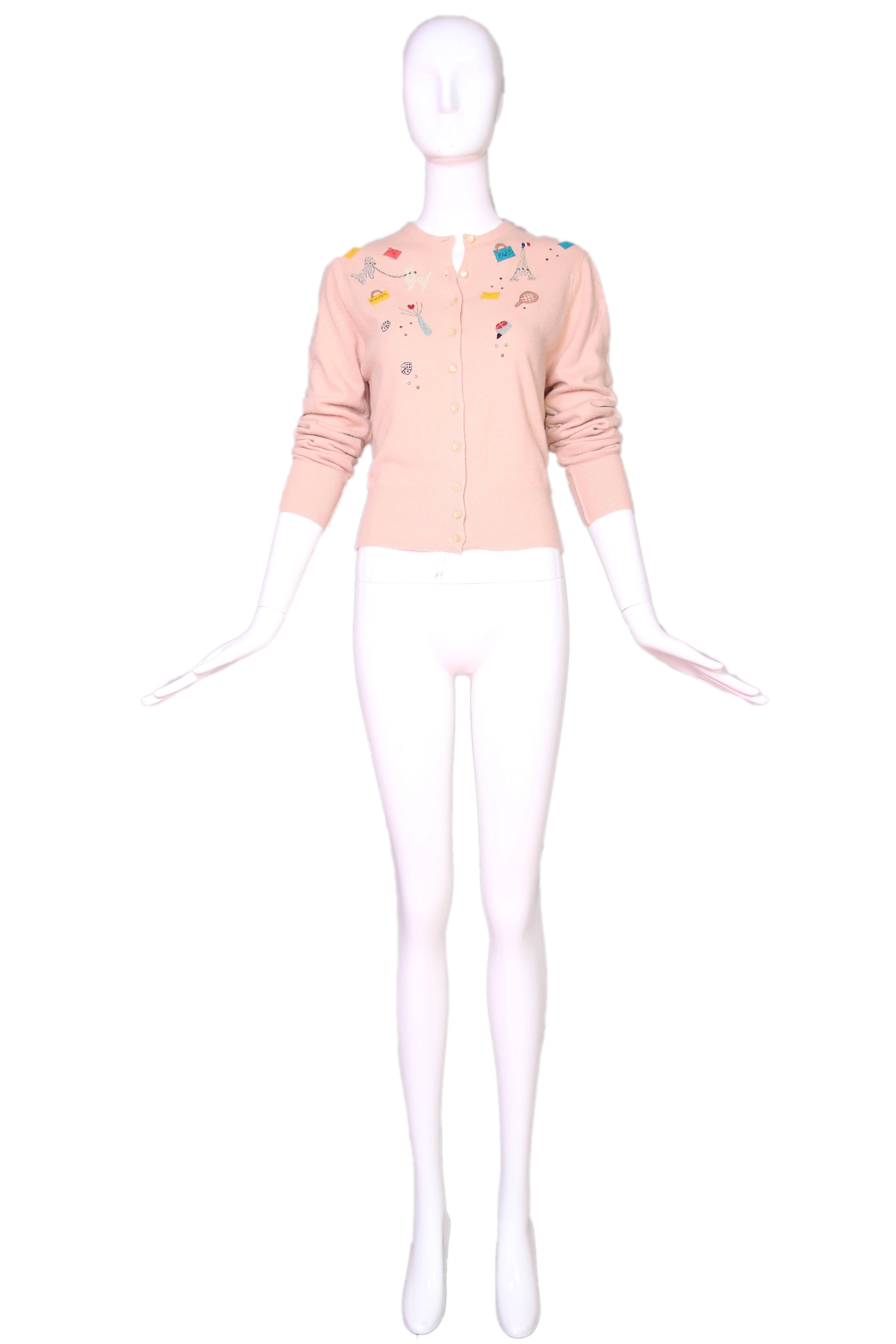 Vintage Schiaparelli label pale pink cashmere cardigan with novelty travel theme and pearlized buttons. In excellent condition. No size tag.
MEASUREMENTS:
Bust - 34