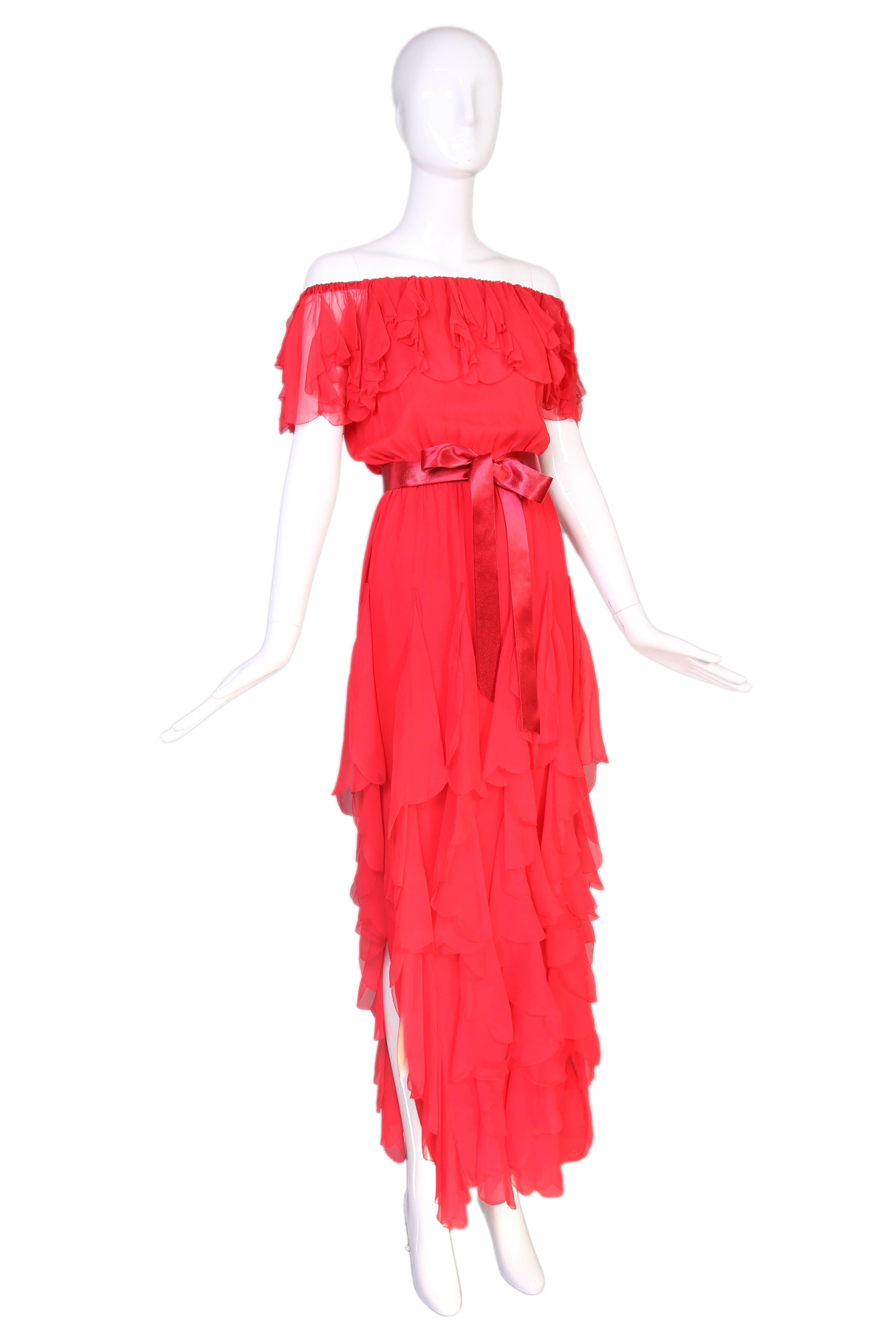 1970's Yves Saint Laurent red silk chiffon evening gown with layered scalloped ruffles at the neckline and long, vertical scallop-edged ruffles at intervals down the entire the skirt. Waist is elastic as is the neckline - which can be worn off the
