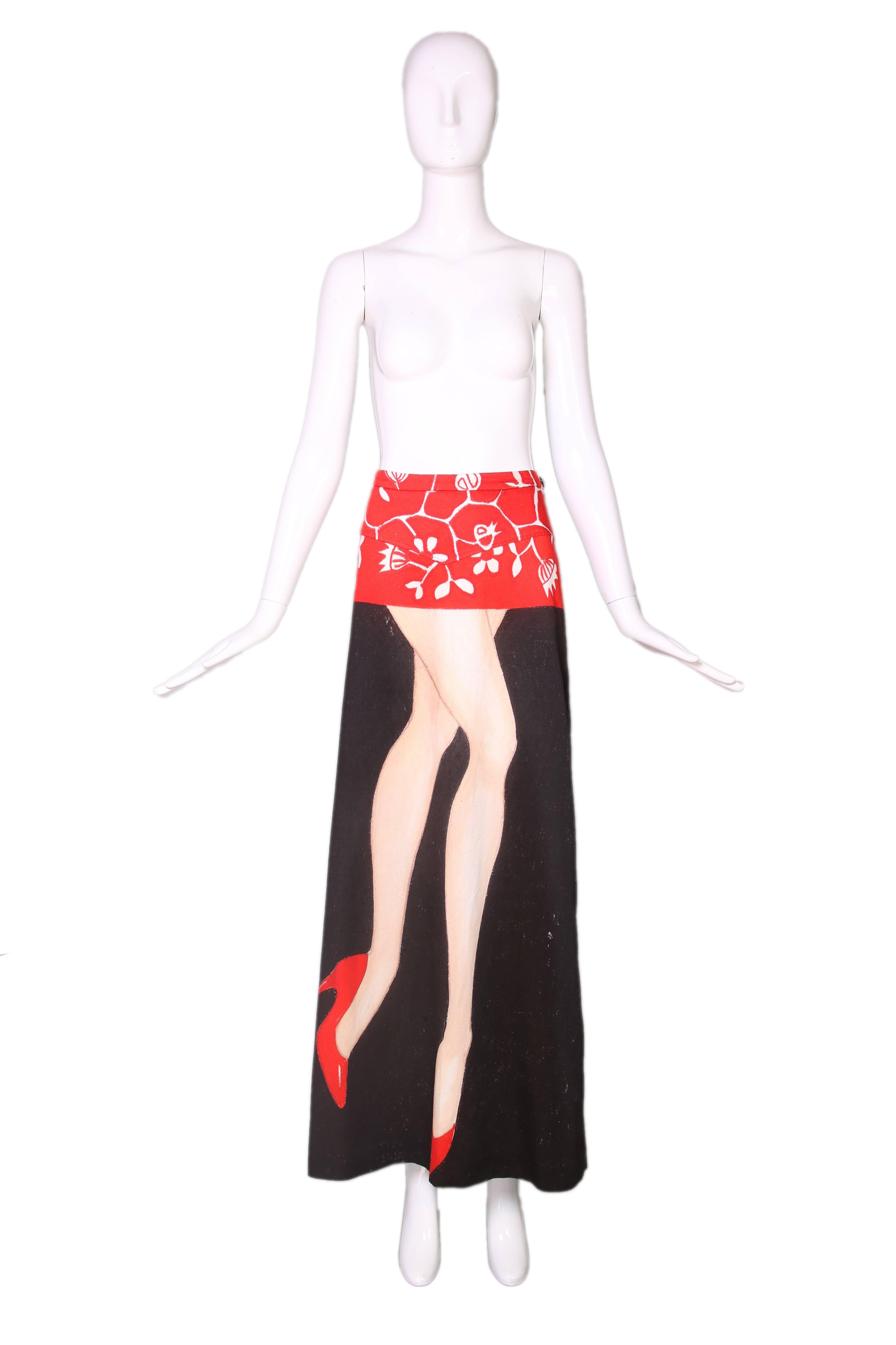 2008 Dirk Van Saene of Antwerp Six black & red cotton maxi skirt with red and white floral design at the top, and woman's legs down the front. Long kick pleat at back hem. Signed by Dirk Van Saene. In excellent condition. Size EU