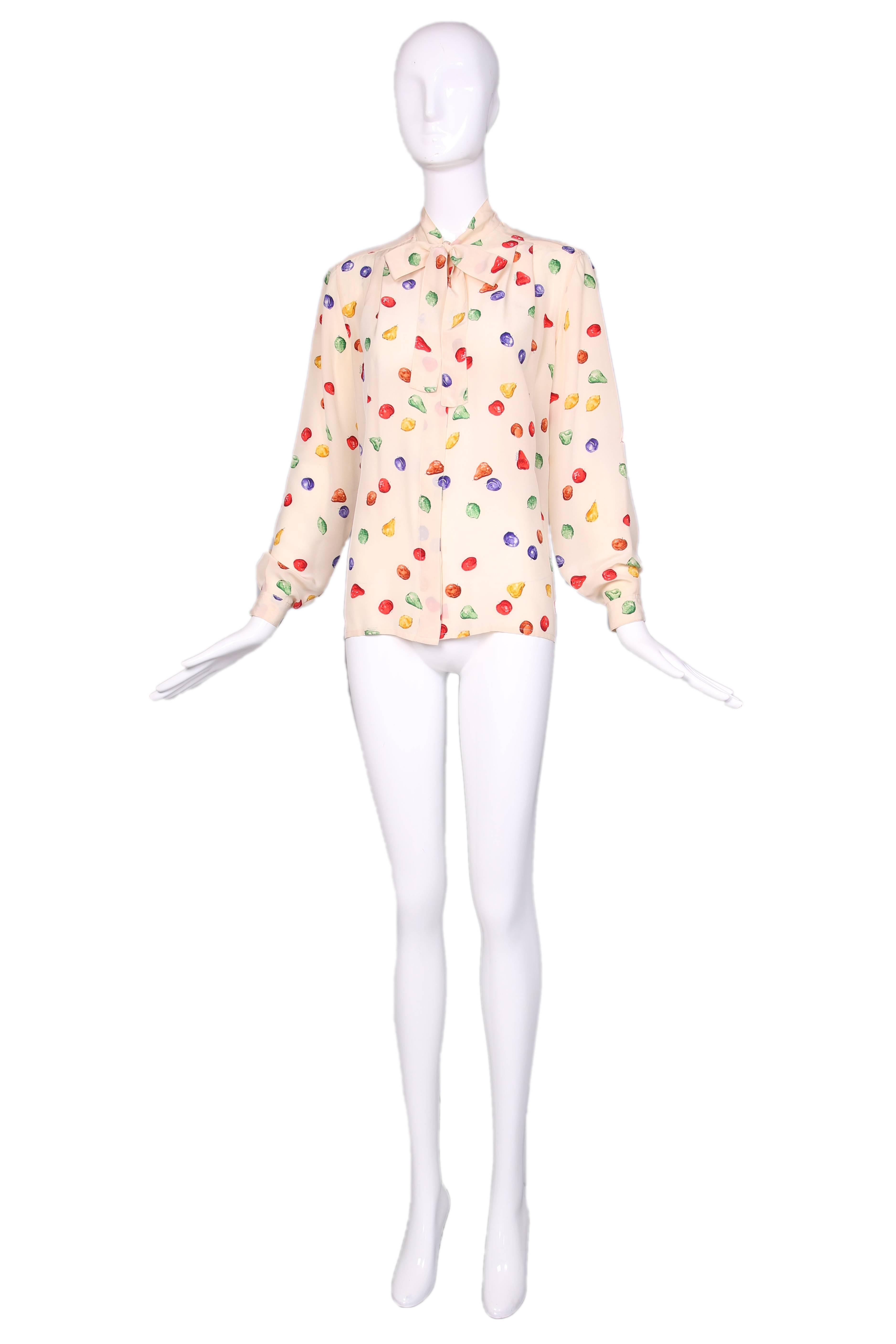 1970's Gucci creme silk long sleeved blouse with print featuring multi-colored fruit and ties at the neck. In excellent condition. No size tag, please consult measurements.
MEASUREMENTS:
Bust - 42