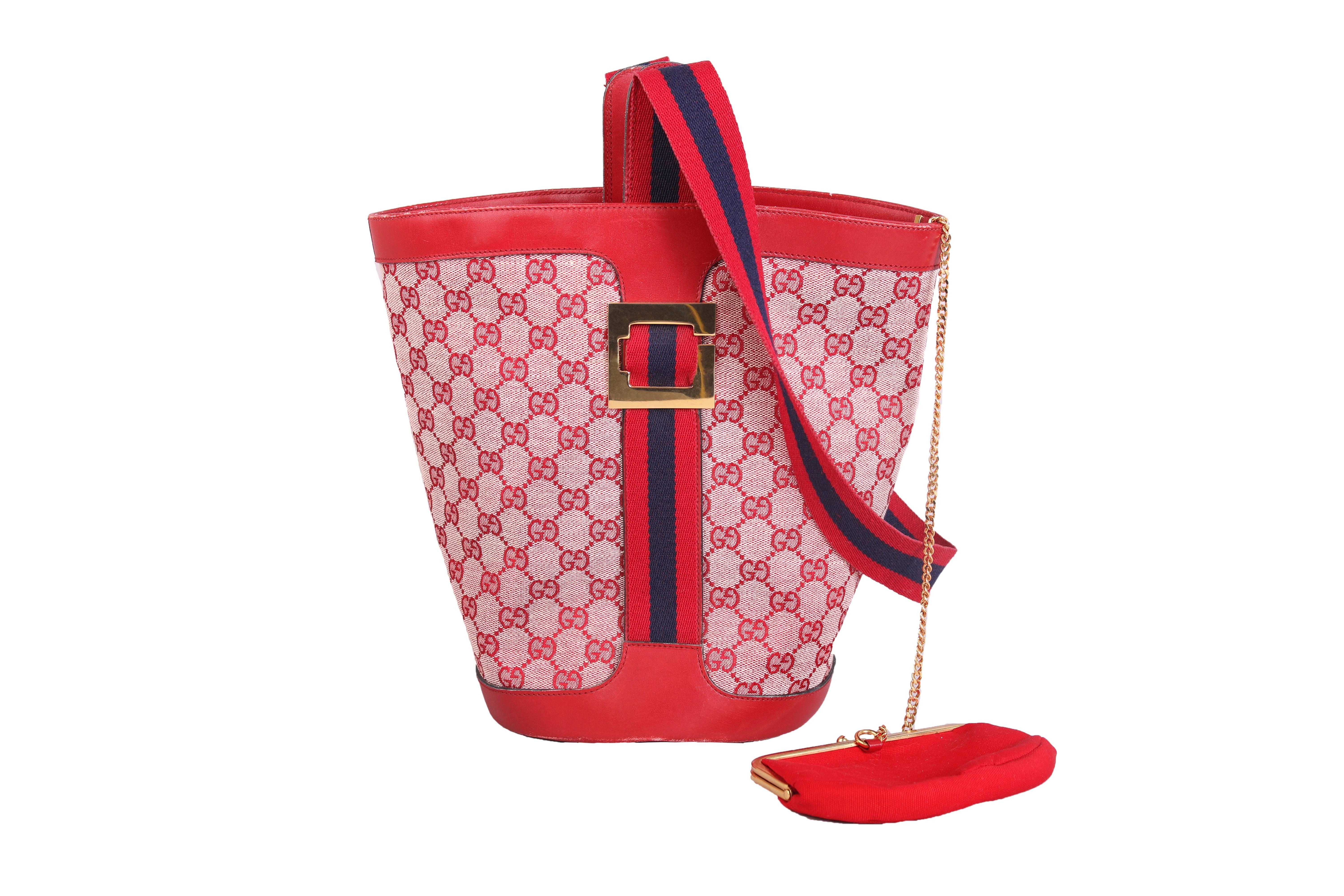 1970's Gucci red canvas GG logo diamond pattern print bucket bag with red leather trim and gold hardware. Comes with a matching coin purse attached by a chain at the interior. Red canvas lined interior. In excellent condition.