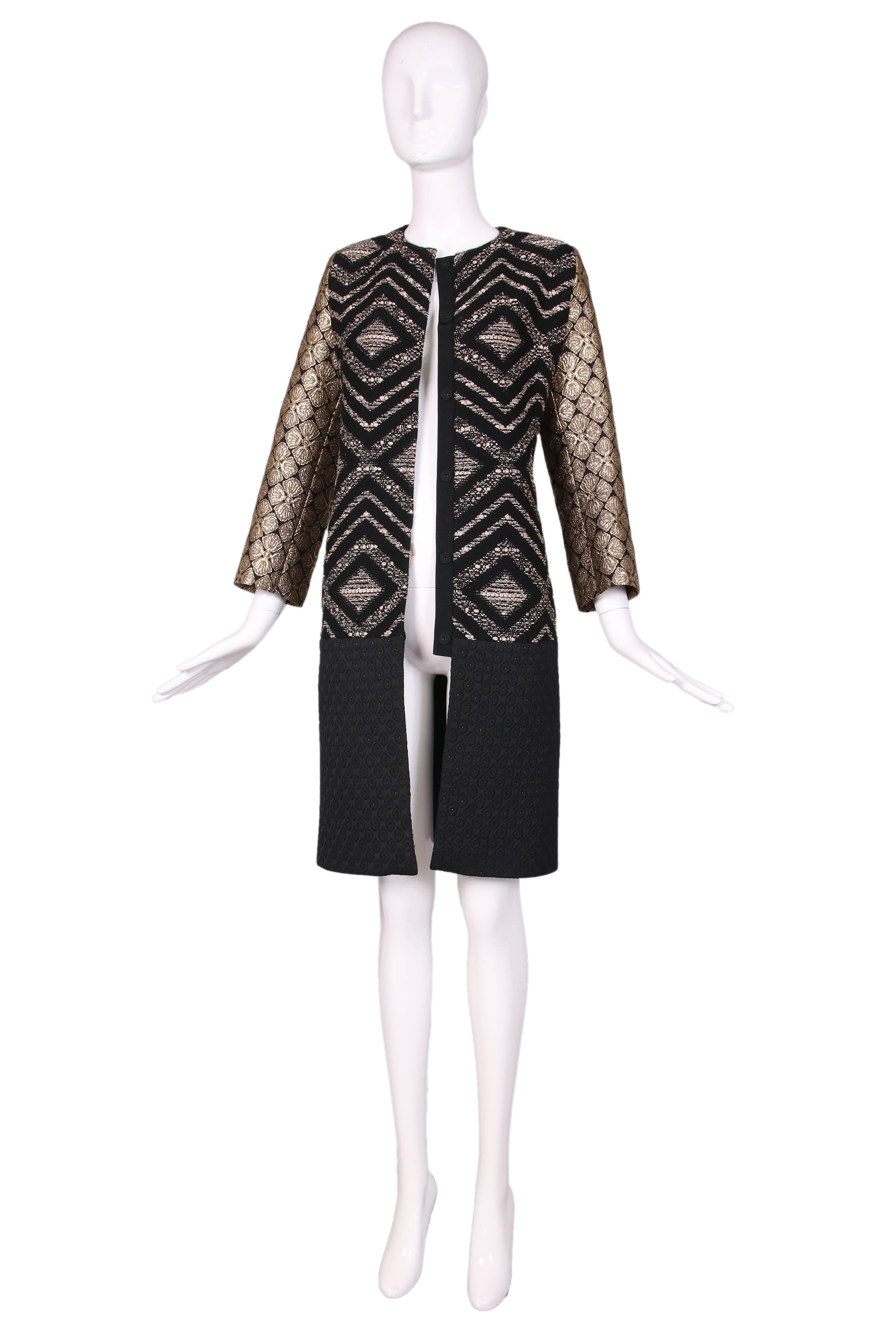 Giambattista Valli black & gold diamond pattern brocade and wool coat w/bottom half in black diamond pattern quilted fabric. Snap closure up center front. In excellent condition.
MEASUREMENTS:
Bust - 36