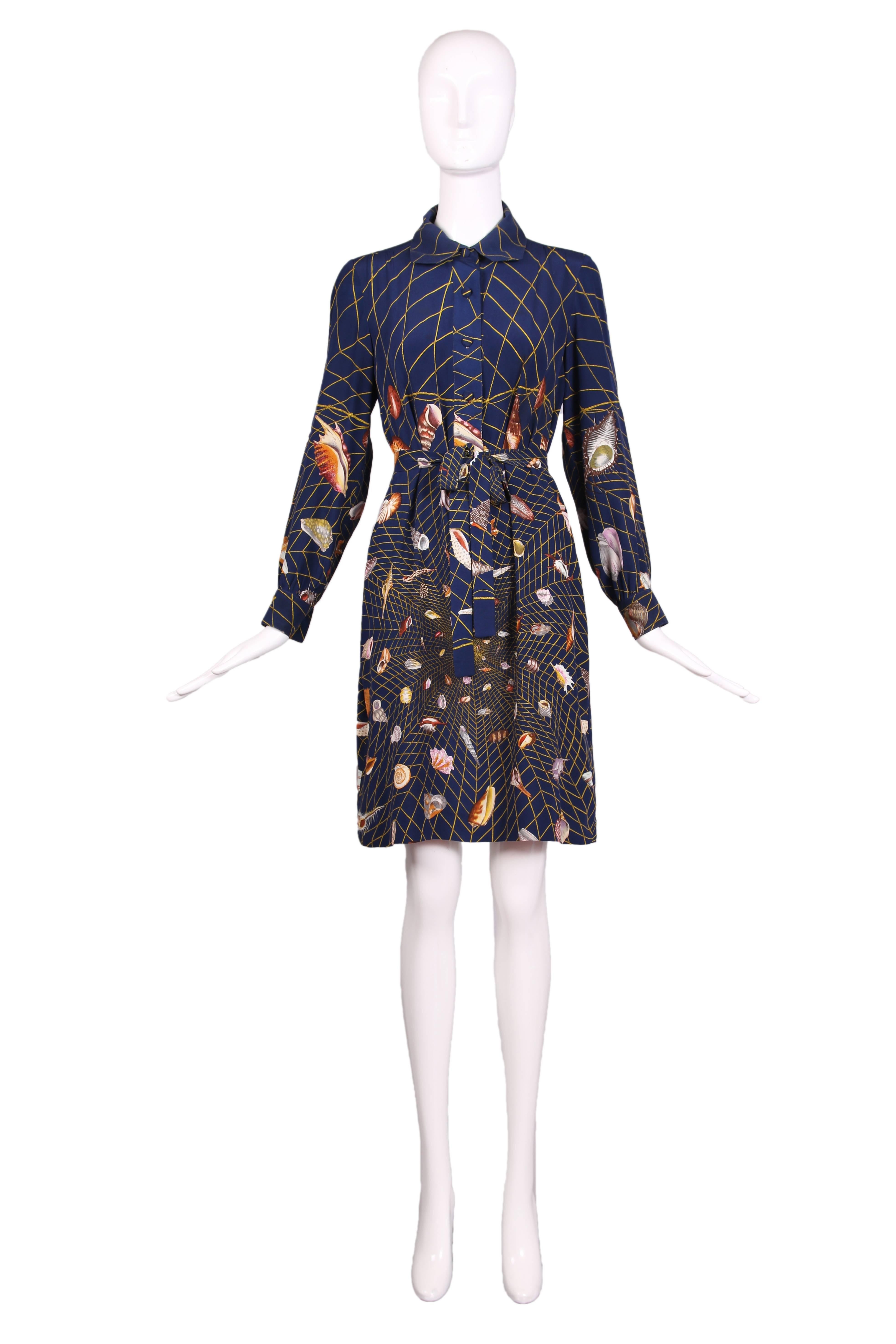 1970's Gucci long sleeved collared silk shirtdress in navy and featuring the iconic, graphic shell print set against a geometric net design. Comes with matching waist tie. In excellent condition. Size IT 44. 
MEASUREMENTS:
Bust - 38"
Waist -