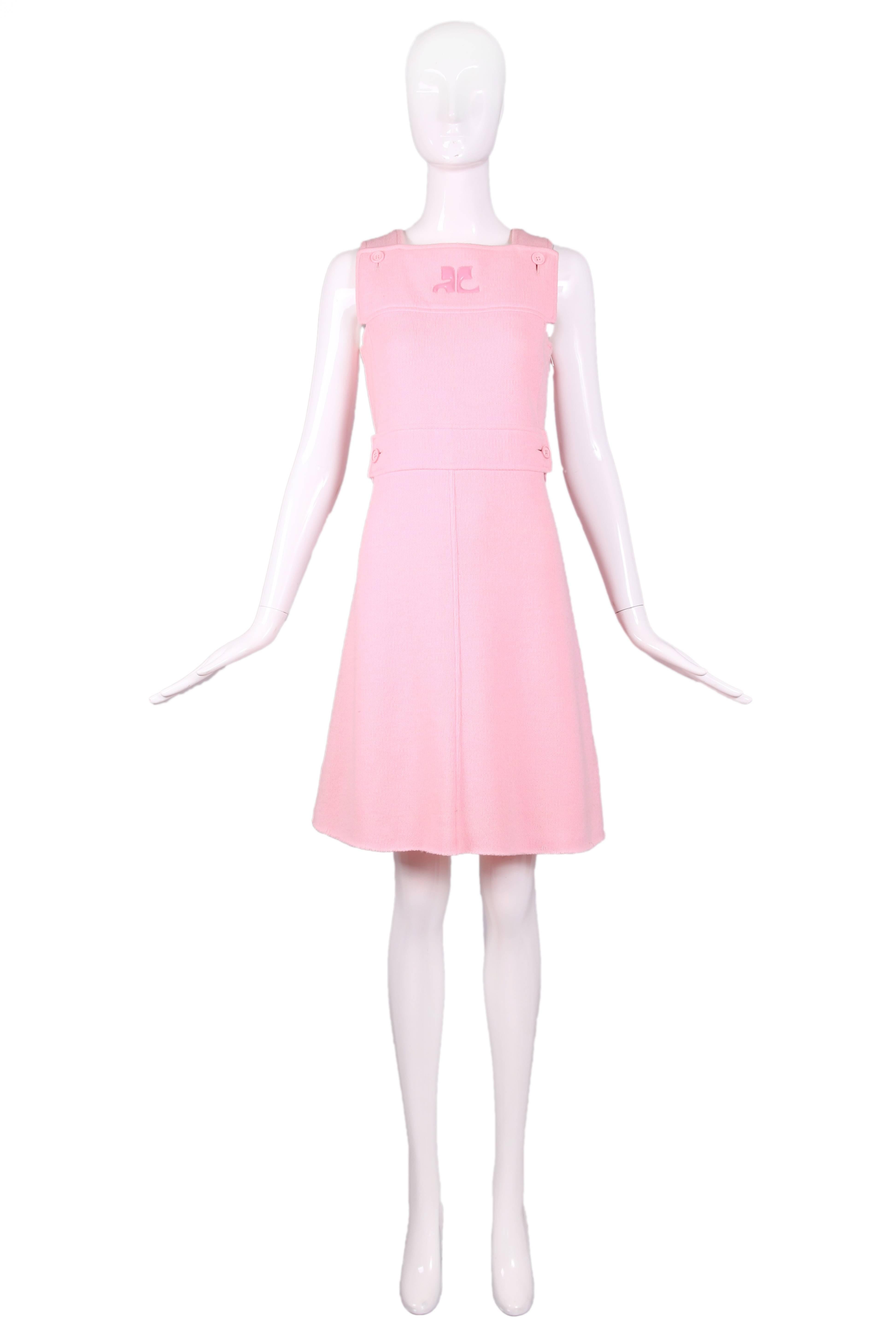 1973 Courreges baby pink wool pinafore dress with waist placket, pink button detail, and Courreges logo at center front. Side zipper closure and snap closure at strap. In excellent condition. Size Courreges b.
MEASUREMENTS:
Bust - 34"
Waist -